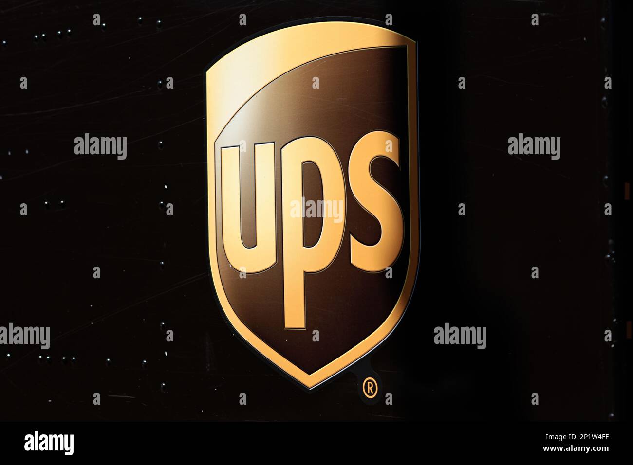 United Postal Service, logo del marchio UPS in lettere dorate sul camion di consegna marrone Foto Stock