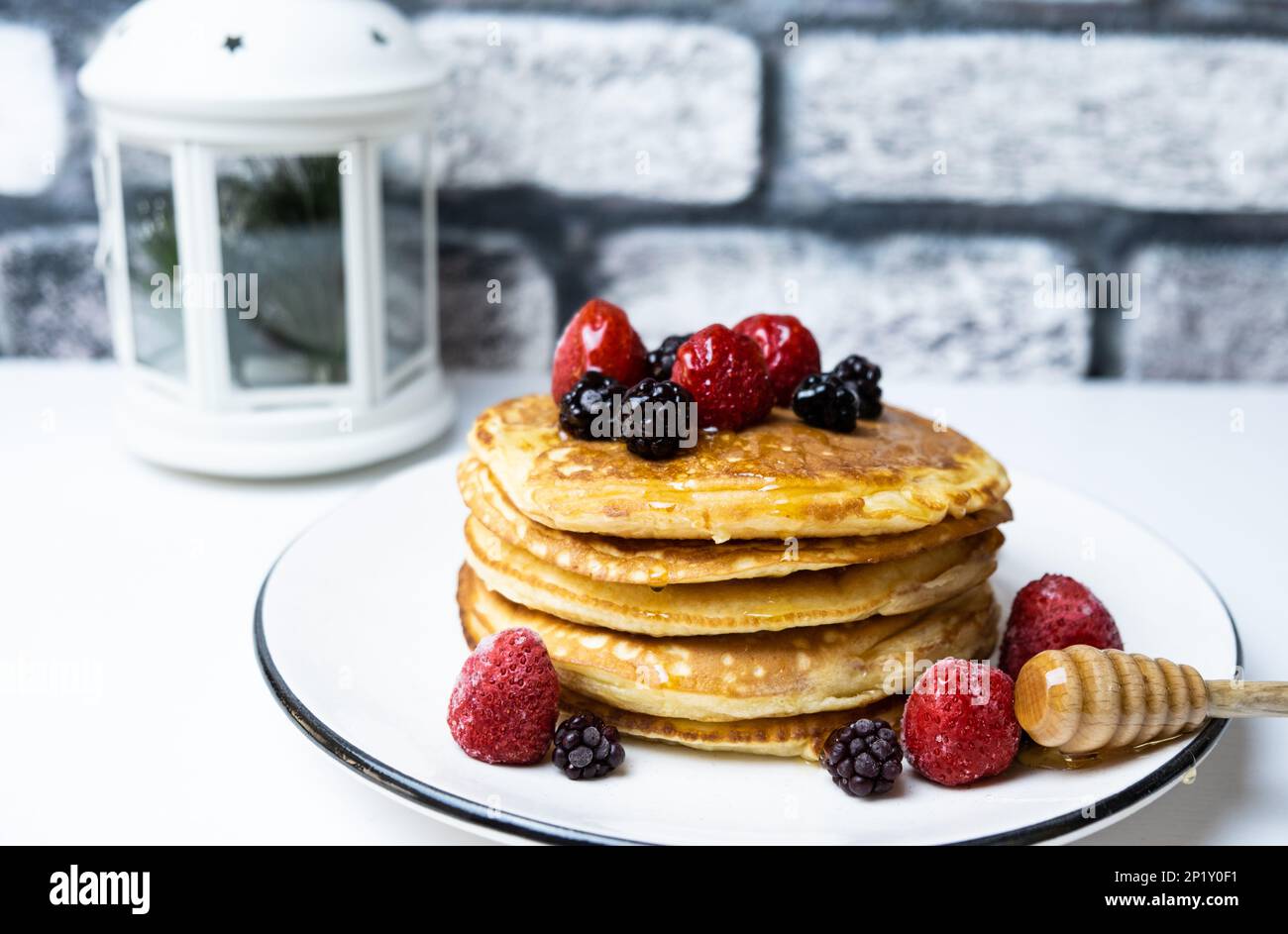 Deliziosi pancake con fragola, mora e miele, primo piano. Foto Stock