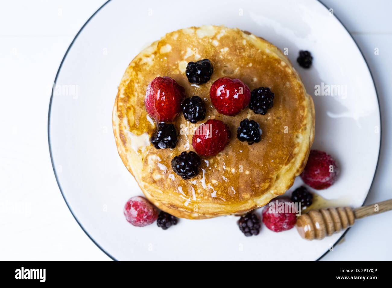 Deliziosi pancake con fragola, mora e miele, vista dall'alto. Foto Stock