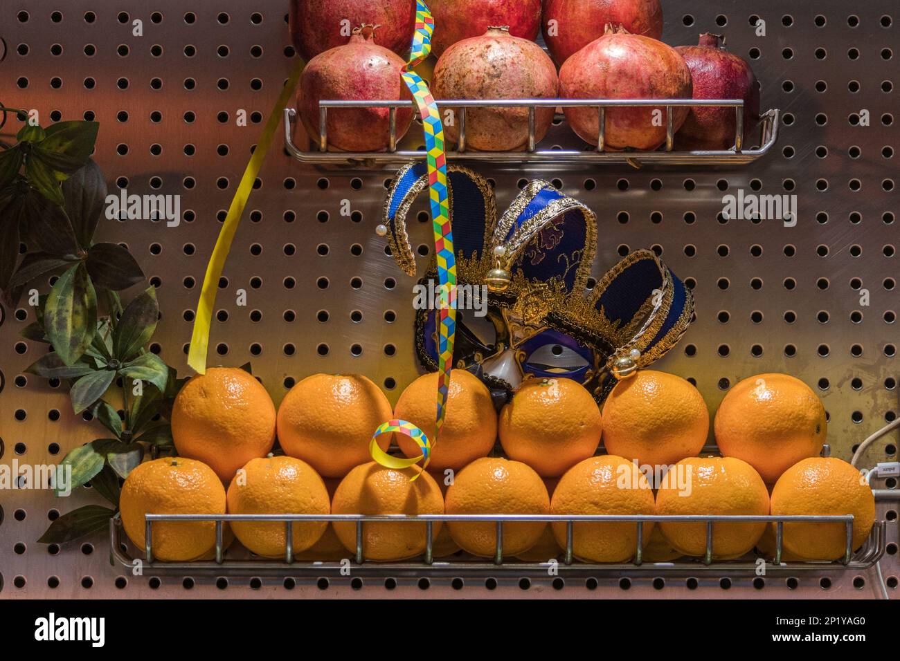 Composizione tra frutta fresca e maschere di Carnevale. Foto Stock