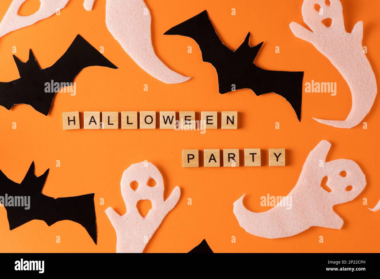 Fantasmi bianchi e mazza per la festa di Halloween. Immagine fantasma della carta di avvolgimento su sfondo arancione vista dall'alto. Fumetto Creepy Whisper. Fai-da-te fatto a mano. Impostare i caratteri boo. Parola frase di legno della lettera. Foto Stock