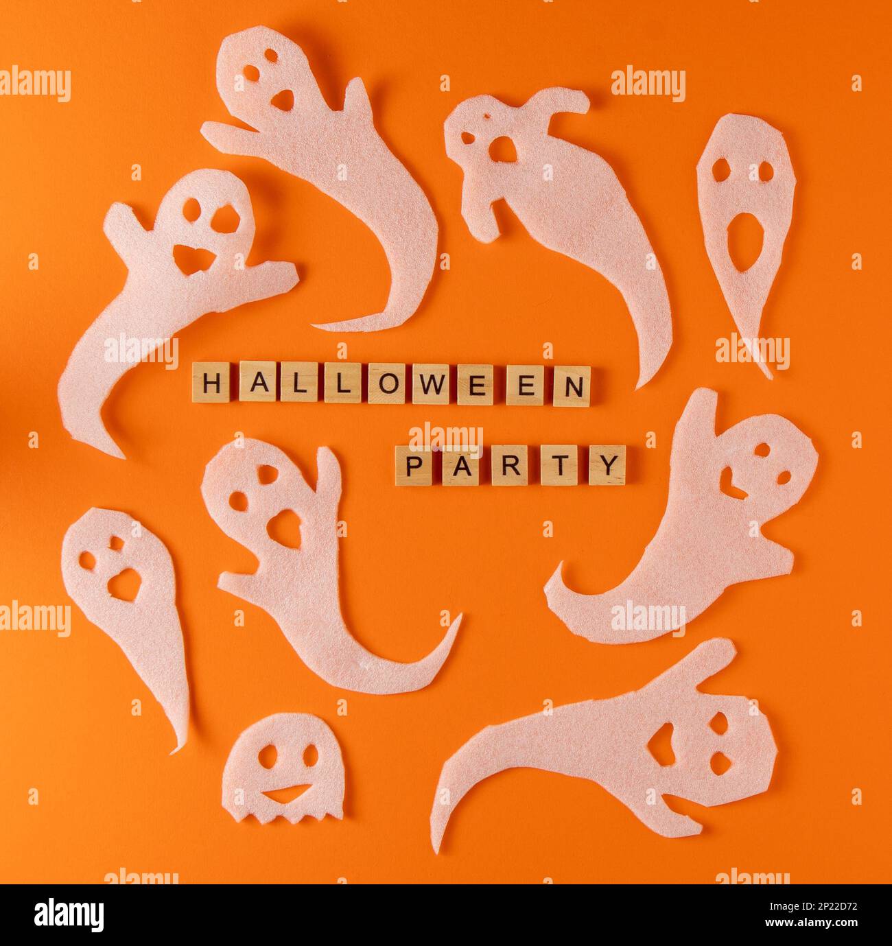 Fantasmi bianchi per la festa di Halloween. Immagine fantasma della carta di avvolgimento su sfondo arancione vista dall'alto. Fumetto Creepy Whisper. Fai-da-te fatto a mano. Impostare i caratteri boo. Parola frase di legno della lettera. Foto Stock