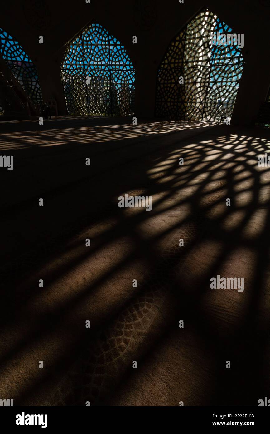 Foto di sfondo verticale islamica o Ramadan. Moschea con ombre. L'ombra dei disegni geometrici islamici sul terreno di una moschea. Foto Stock