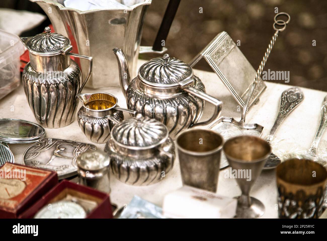 Argento antico teiere, creamer e altri utensili in un mercato delle pulci. Vecchi articoli metallici da tavola gli oggetti collezionabili in una vendita di garage Foto Stock