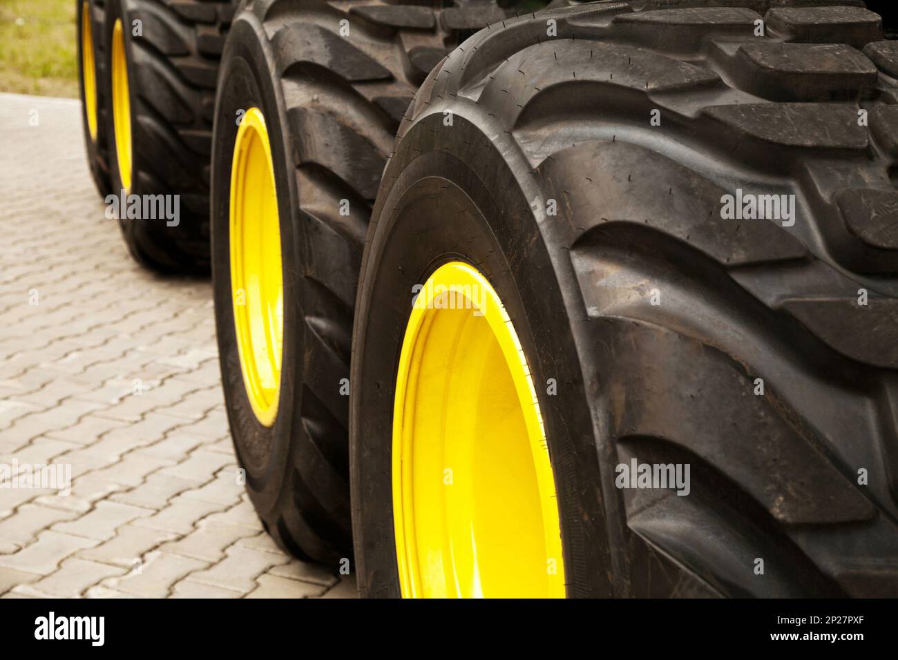 Fila di grandi ruote gialle del camion sfondo. Pneumatici per trattori industriali enormi Foto Stock