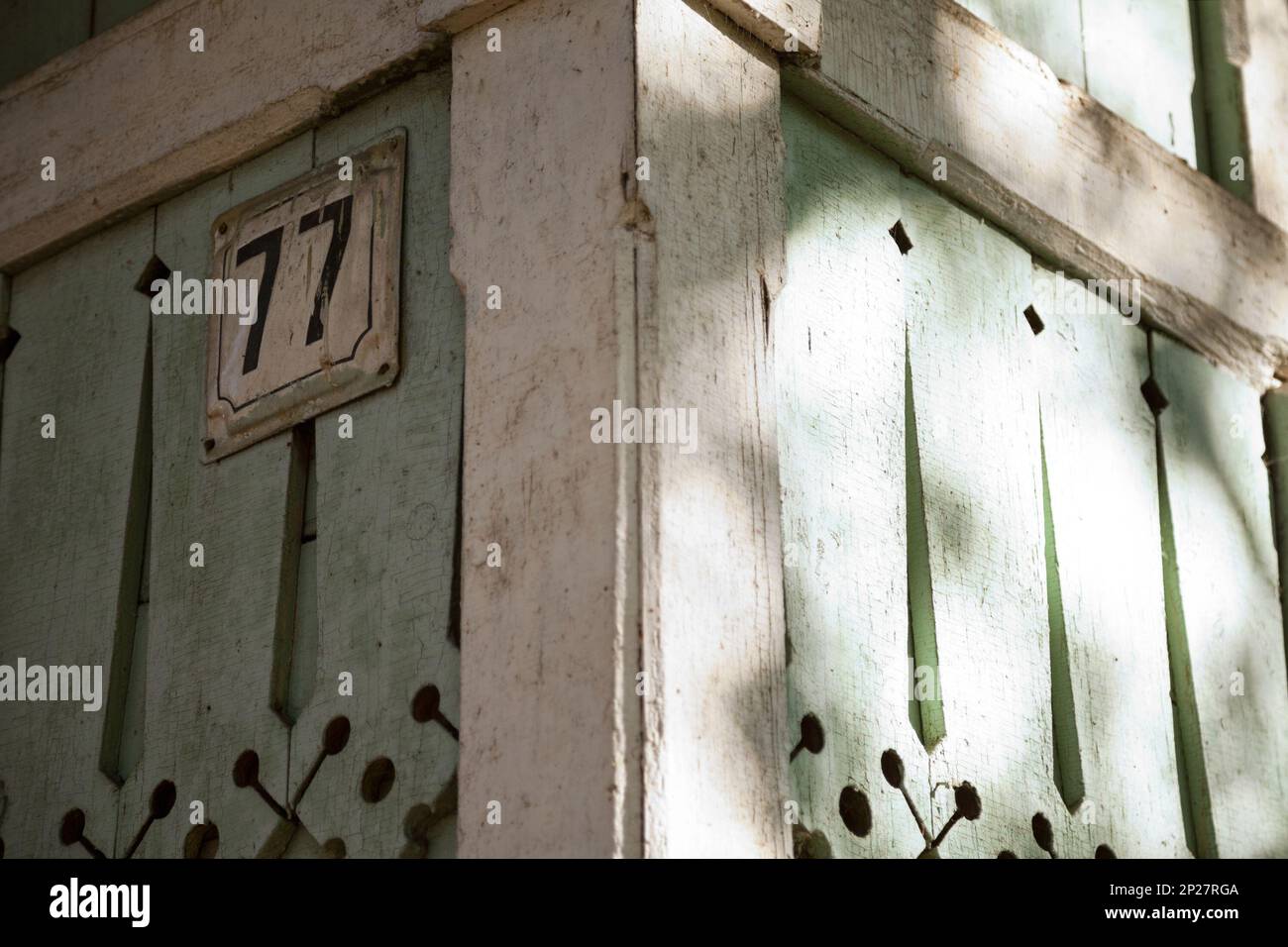 Tradizionale casa russa in legno con targa primo piano. Decorazioni in legno intagliato su un edificio verde rustico. Dettagli architettonici Foto Stock