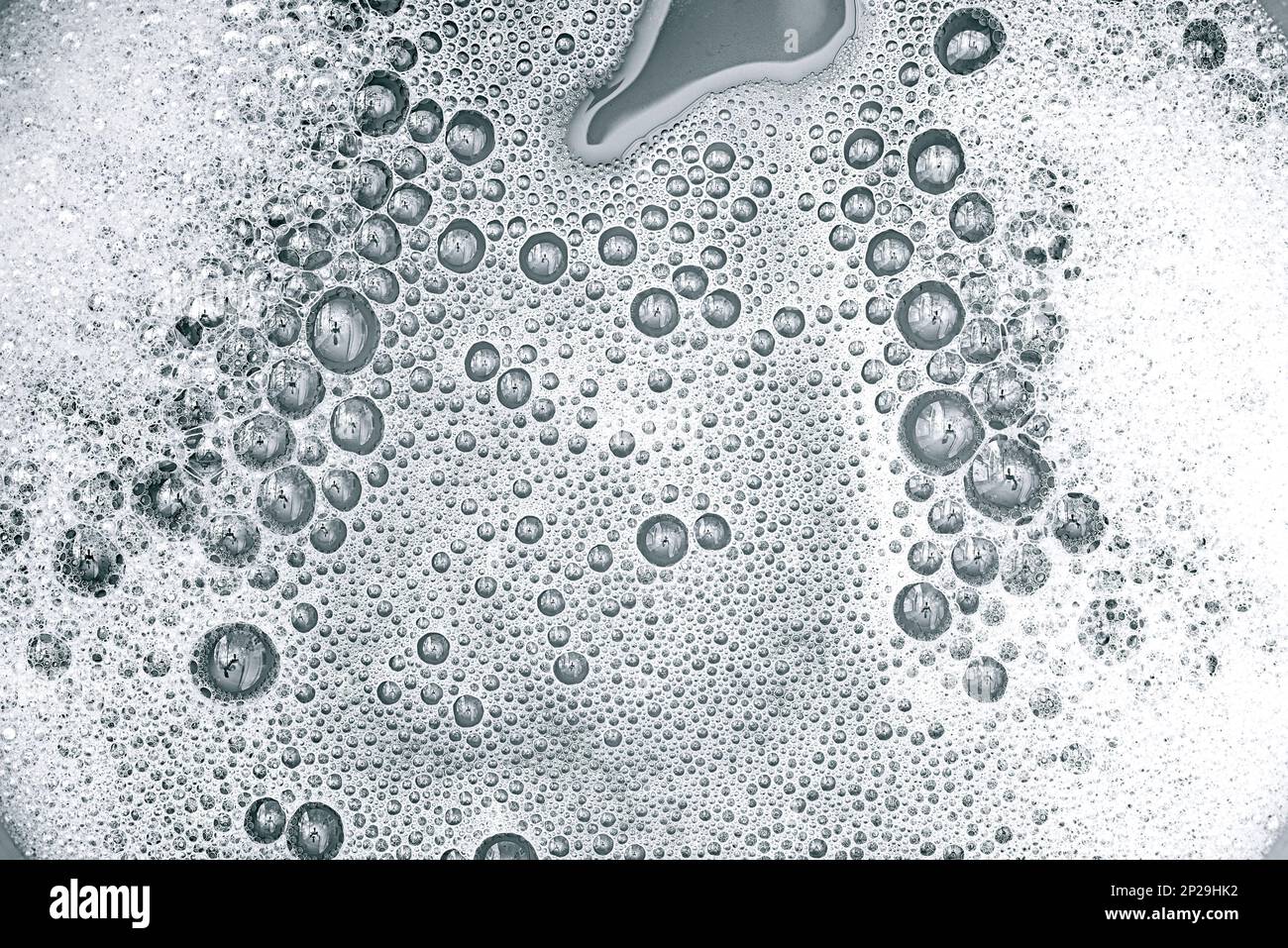 Schiuma bianca e sapone sulla superficie dell'acqua come consistenza o sfondo Foto Stock