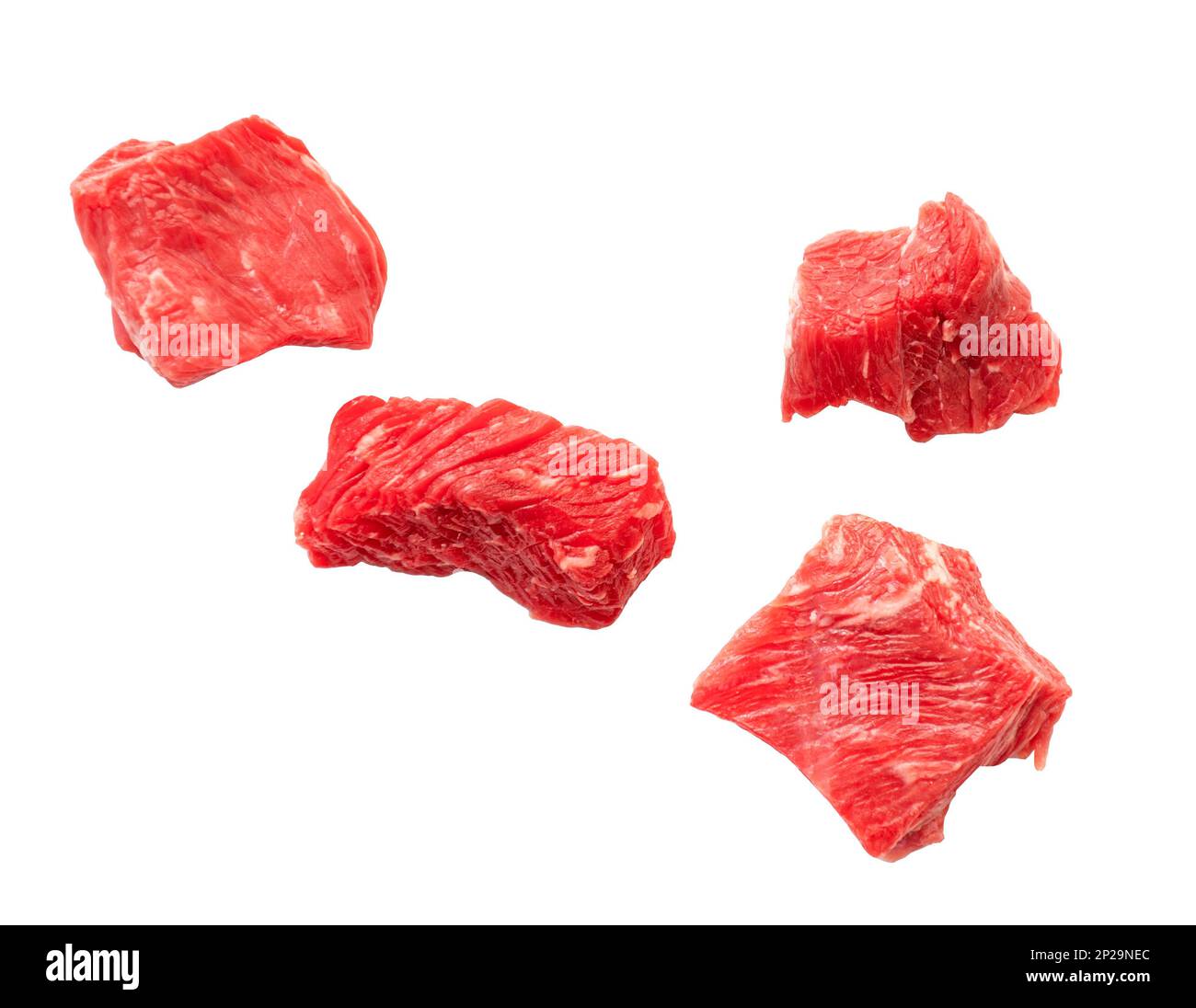 Pezzi di carne bovina cruda che cadono e sono isolati su bianco. Fette di carne rossa tagliata Foto Stock