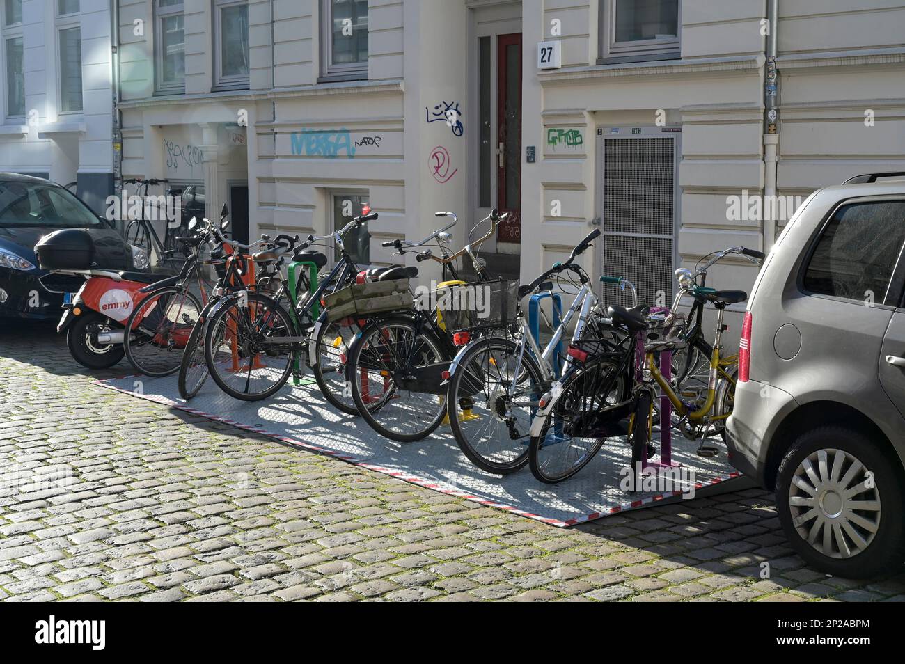 GERMANIA, Amburgo, città verde, passaggio del traffico, parcheggio per biciclette su strada / DEUTSCHLAND, Amburgo, velo City, Fahrrad Parkplatz auf der Straße anstelle eines PKW Parkplatzes, ein Auto zwölf Fahrräder Foto Stock