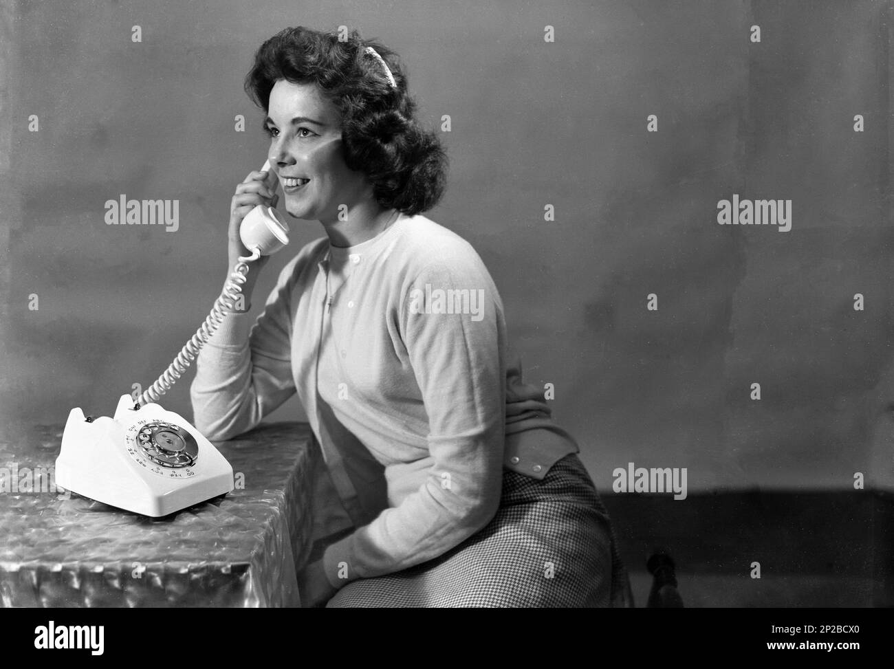 1950s, histrical, giovane donna che parla al telefono, Inghilterra, Regno Unito. Foto Stock