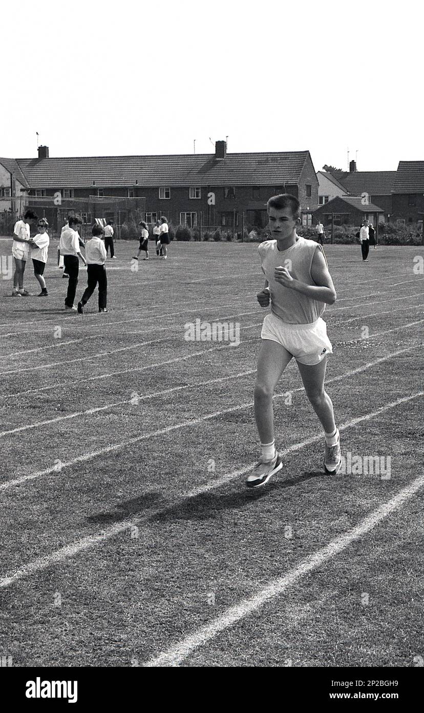 1989, giornata di sport in una scuola secondaria, un adolescente in testa in una corsa su una pista d'erba, Sleaford, Lincs, Inghilterra, Regno Unito. Foto Stock