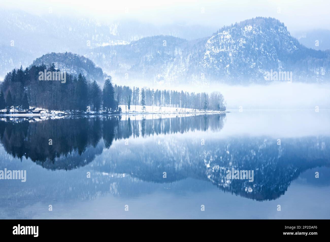 Montagne coperte di ghiaccio vicino al lago e mirrorings che costruiscono un paesaggio simmetrico Foto Stock