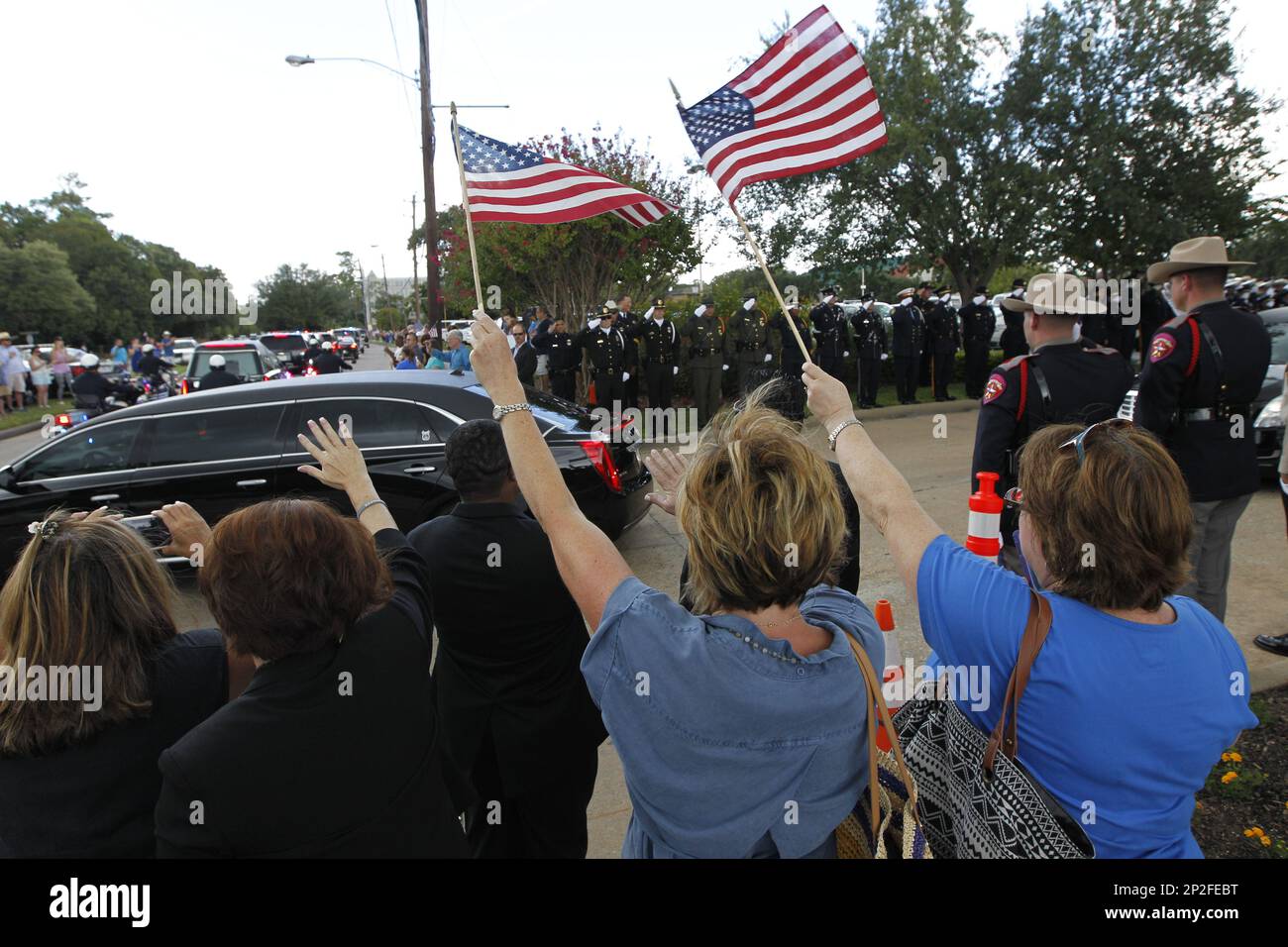 People wave flags during the funeral procession for slain Harris County Sheriff's Deputy Darren Goforth makes its way along Antoine Drive Friday, Sept. 4, 2015, in Houston. Goforth was killed a week ago while filling his patrol car with gasoline at a suburban Houston convenience store. A 30-year-old Houston man is charged with his slaying. (Steve Gonzales/Houston Chronicle via AP) MANDATORY CREDIT Foto Stock