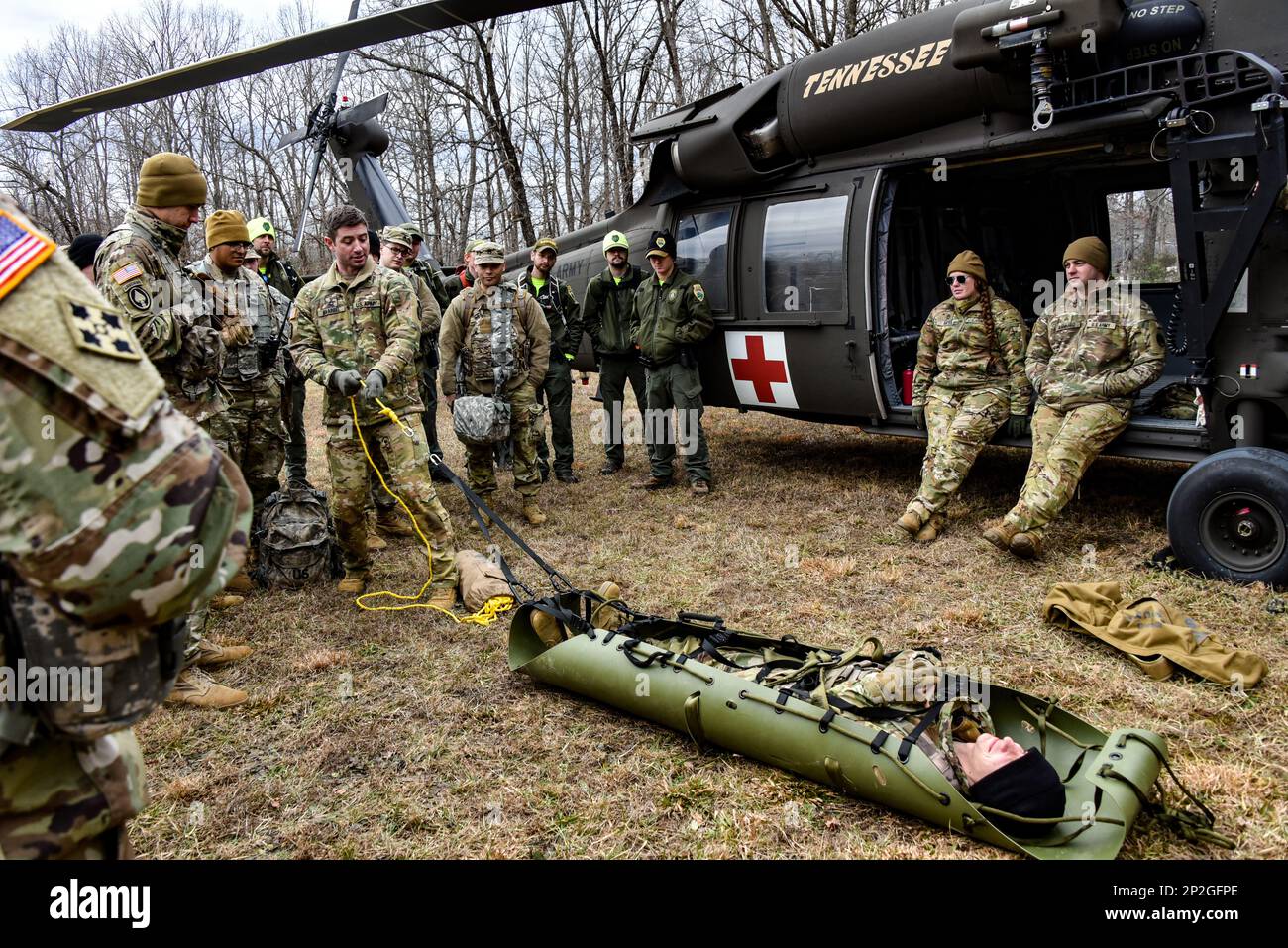 I soldati del battaglione di artiglieria della Guardia Nazionale del Tennessee (1-181st) e i membri della Guardia di Stato del Tennessee ascoltano le istruzioni sul recupero delle persone ferite e sulla loro preparazione per il medevac da parte dei membri del battaglione di elicottero d'assalto (1-230th) durante il SAREX 23 nel Pickett state Park vicino a Jamestown, TN 7 gennaio 2023. Il gruppo multi-agenzia ha lavorato per rintracciare, localizzare e evacuare le persone scomparse come parte di un esercizio di formazione con altre agenzie militari e civili per rafforzare le partnership in un ambiente congiunto. Foto Stock