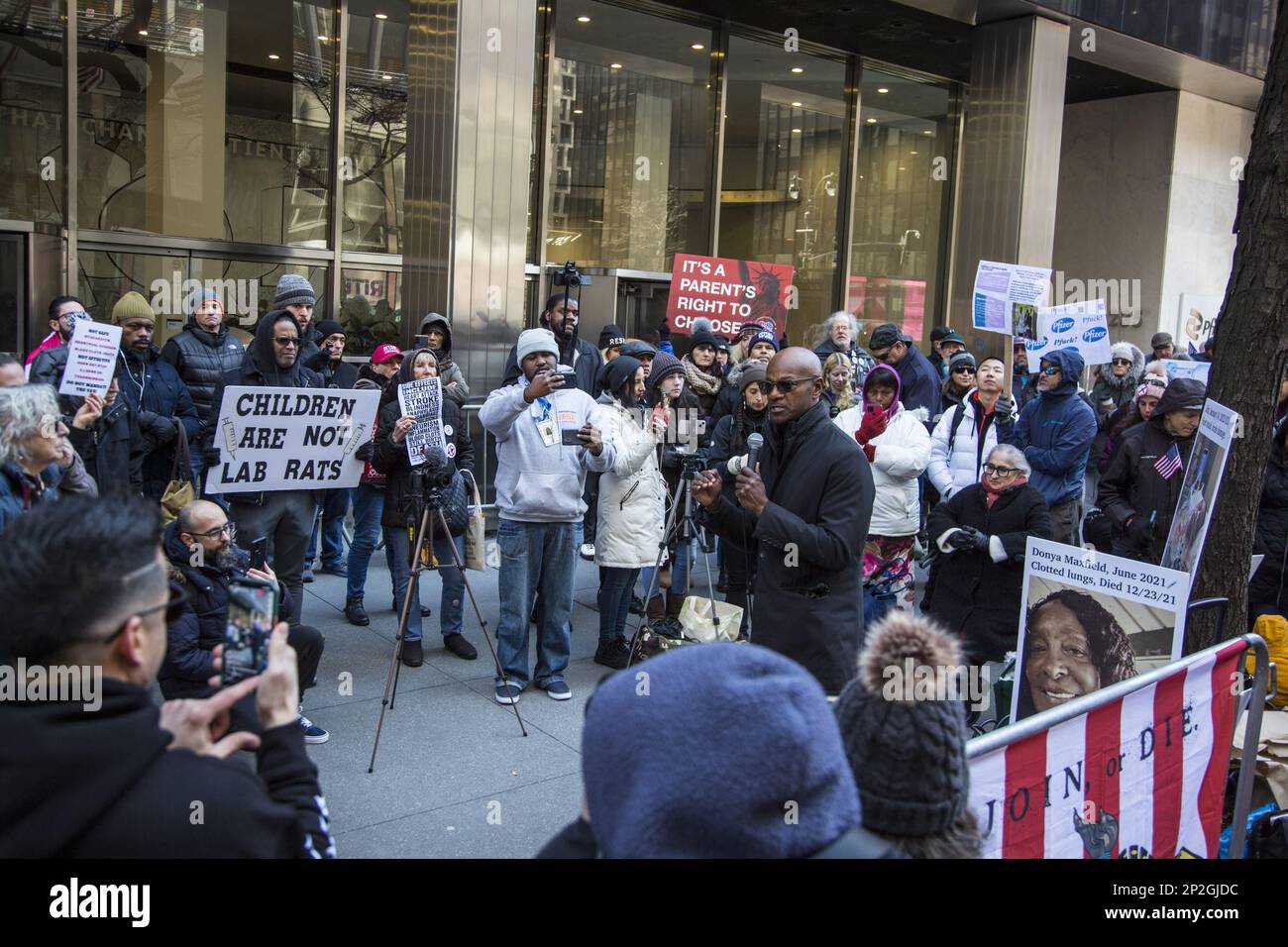 I membri del Medical Freedom Party e altri che mettono in discussione i motivi del profitto dietro la rapida produzione dei vaccini Covid dimostrano di fronte alla sede centrale di Pfizer World sulla 42nd Street a Manhattan, New York City. Foto Stock