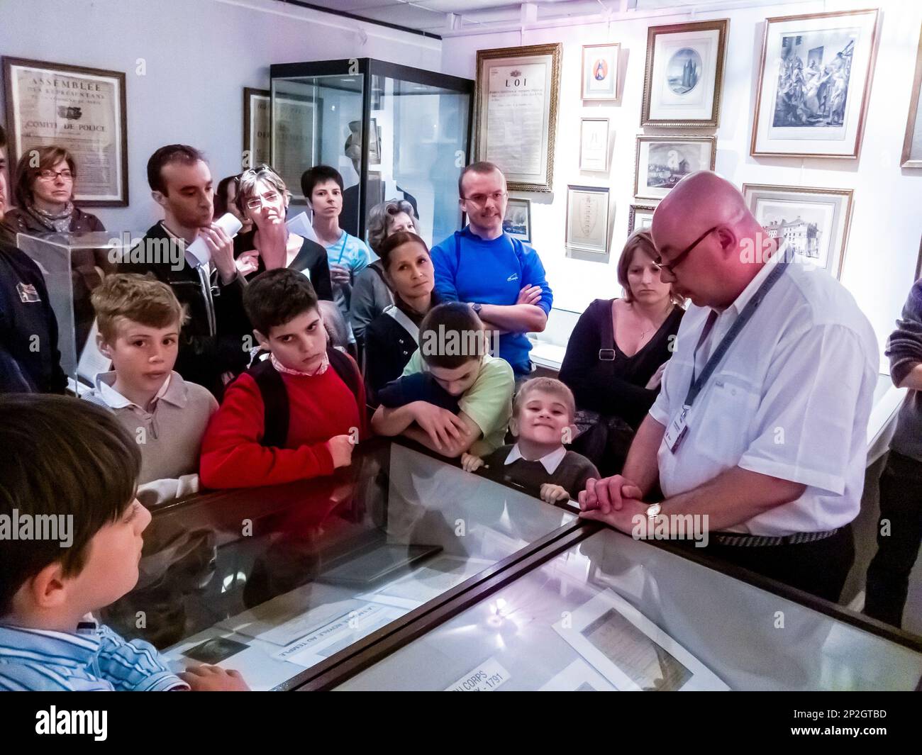 Guida turistica di Parigi, Francia, guida turistica in francese che conduce il gruppo, parla con grandi gruppi di persone, bambini, turisti, all'interno della mostra del Museo della polizia, archivi Foto Stock