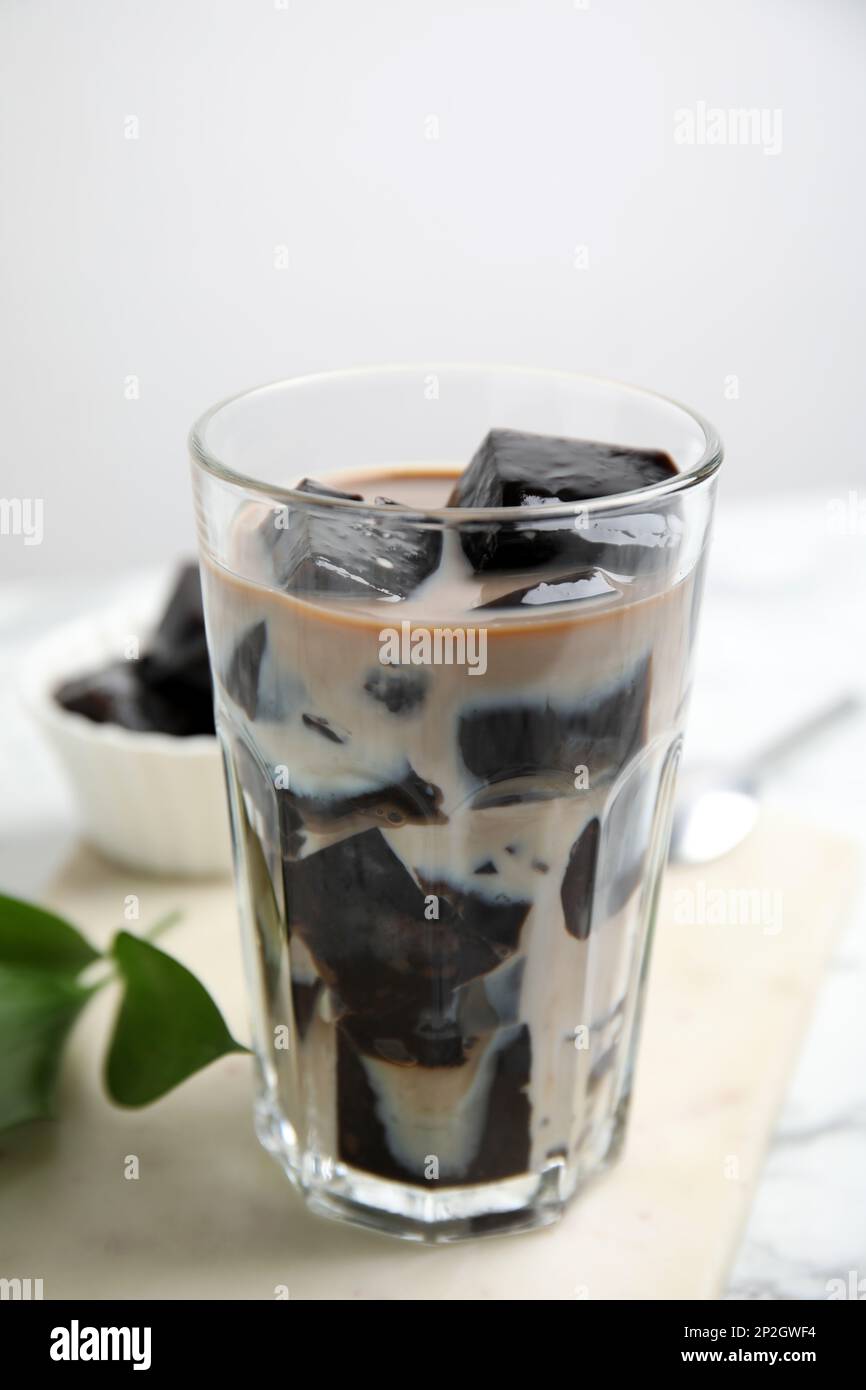 Bicchiere di latte con gelatina d'erba sulla tavola, primo piano Foto Stock