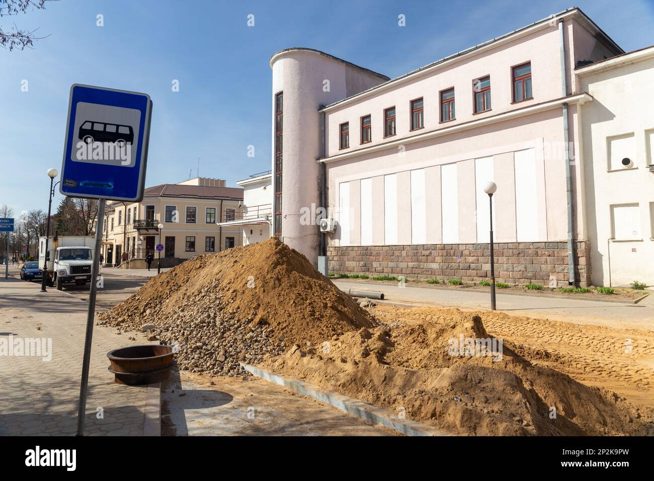 Grodno, Bielorussia - 06 marzo 2022: I lavoratori con l'aiuto di attrezzature per il movimento terra stanno ricostruendo le utenze sotterranee su una delle strade più antiche Foto Stock