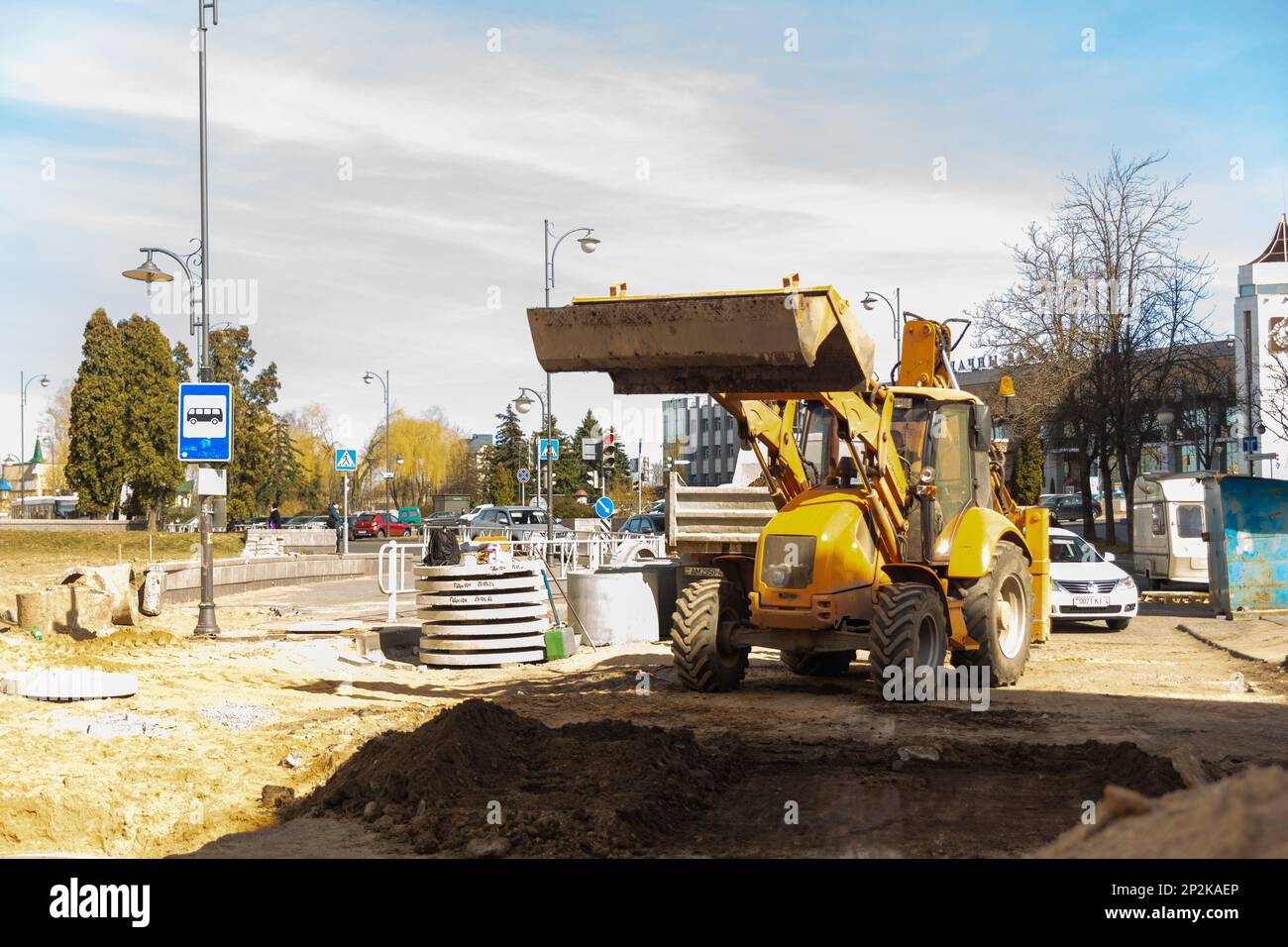 Grodno, Bielorussia - 06 marzo 2022: I lavoratori con l'aiuto di attrezzature per il movimento terra stanno ricostruendo le utenze sotterranee su una delle strade più antiche Foto Stock