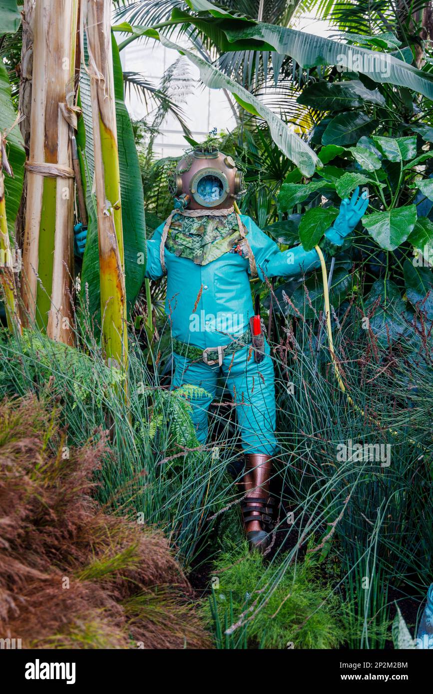 Una figura blu subacquea in un costume da immersione all'evento annuale Houseplant Takeover, a tema Deep Sea Dive, nella Glasshouse a RHS Garden, Wisley Foto Stock