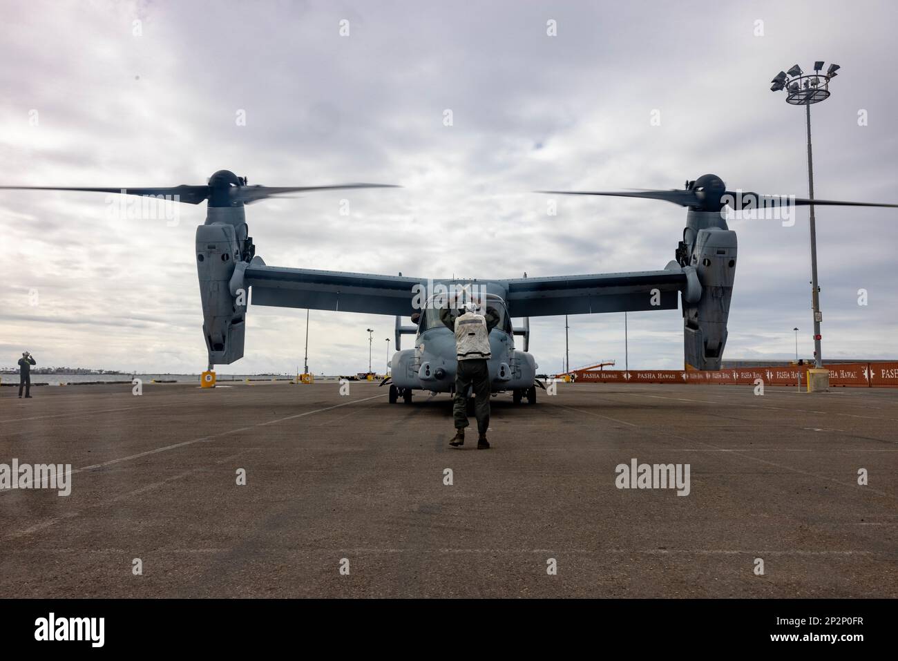 STATI UNITI Edgar Martinez Torres, un meccanico di tiltrotor con Marine Medium Tiltrotor Squadron (VMM) 163, Marine Aircraft Group 16, 3rd Marine Aircraft Wing, guida un'Osprey MV-22B verso l'area di sosta presso il National City Pier a San Diego, 24 febbraio 2023. Lo squadrone ha messo in scena gli Ospreys per il trasporto marittimo per fornire agli elementi di combattimento e supporto dell'aviazione organizzata di compito. Martinez Torres è un nativo di Denver. (STATI UNITI Corpo marino foto di Lance CPL. Courtney A. Robertson) Foto Stock