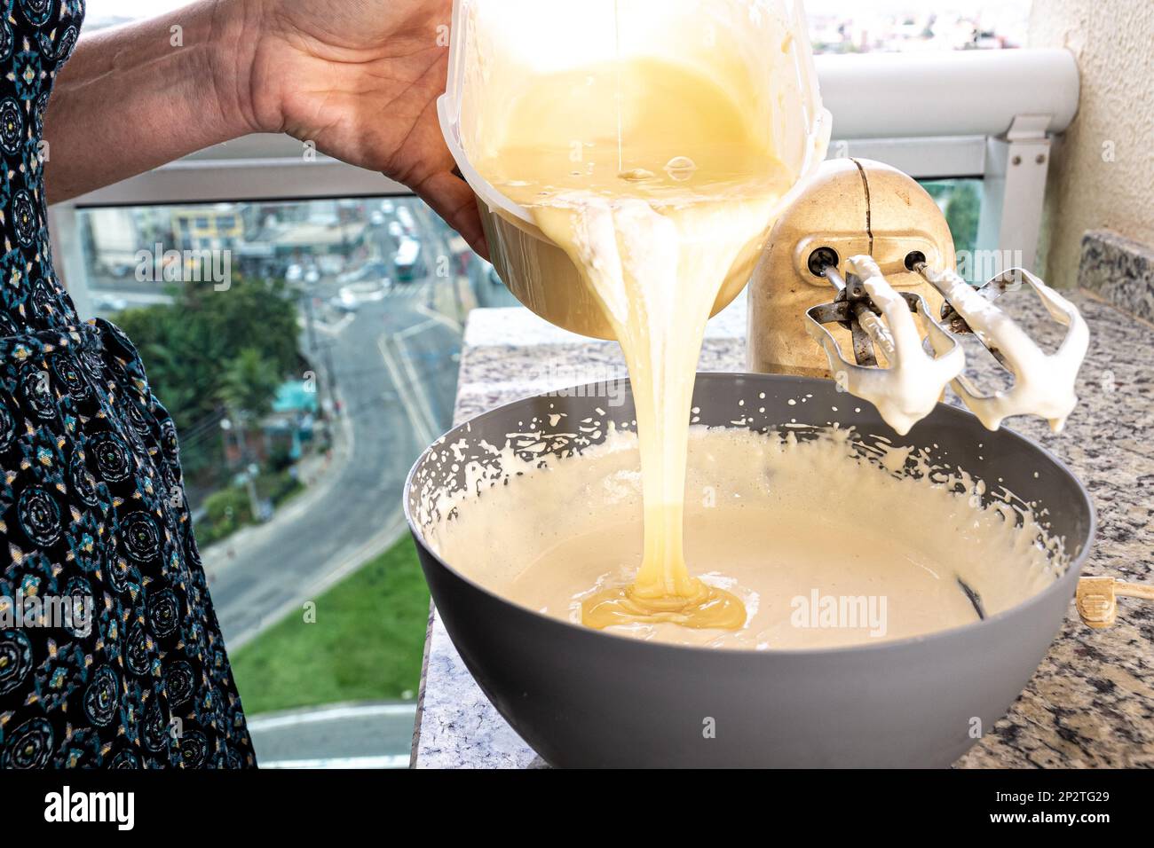 Donna cuoco mettere l'ingrediente nel contenitore di preparazione cheesecake. Gastronomia familiare. Foto Stock