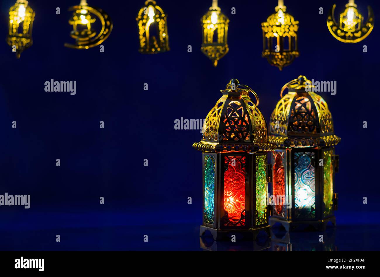 Le lanterne dorate hanno messo sullo sfondo blu scuro con luci decorate per la festa musulmana del mese santo di Ramadan Kareem. Foto Stock