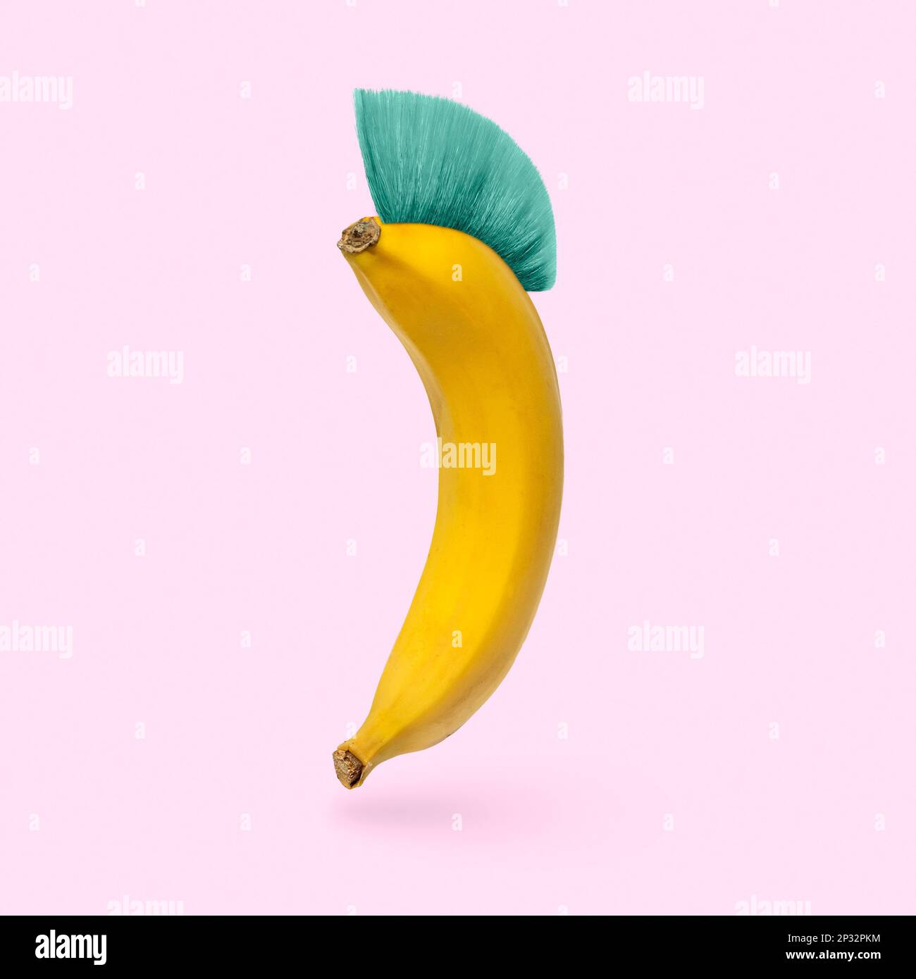 L'umorismo è una banana allegra con un'acconciatura mohawk su uno sfondo rosa. Concetto minimo di umorismo e surreale. Foto di alta qualità Foto Stock