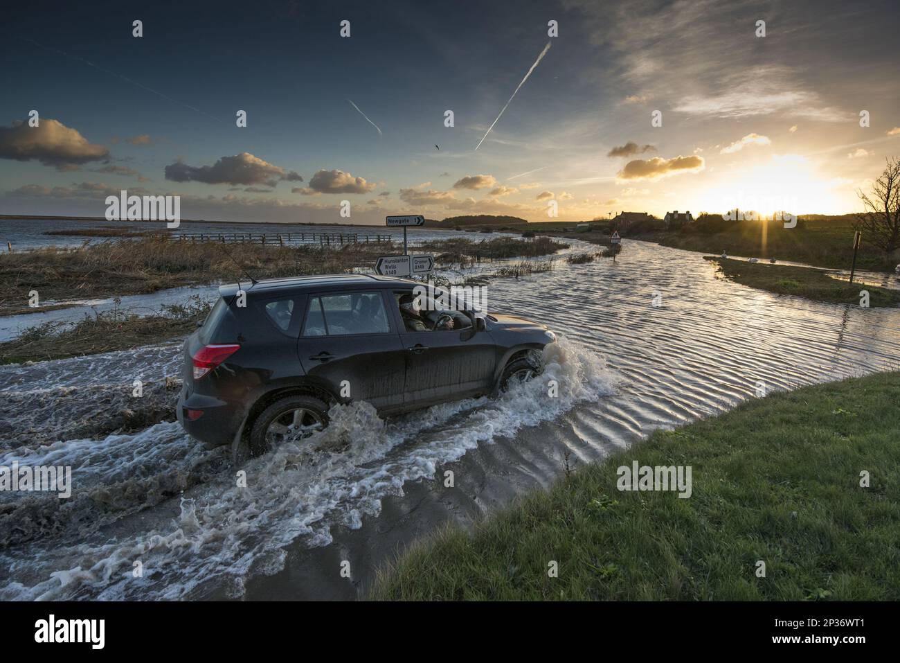 Guida in 4x4 attraverso la strada costiera allagata lungo la palude costiera post-alluvione, Cley Marshes Reserve, Cley-next-the-Sea, North Norfolk, Inghilterra, Dicembre Foto Stock