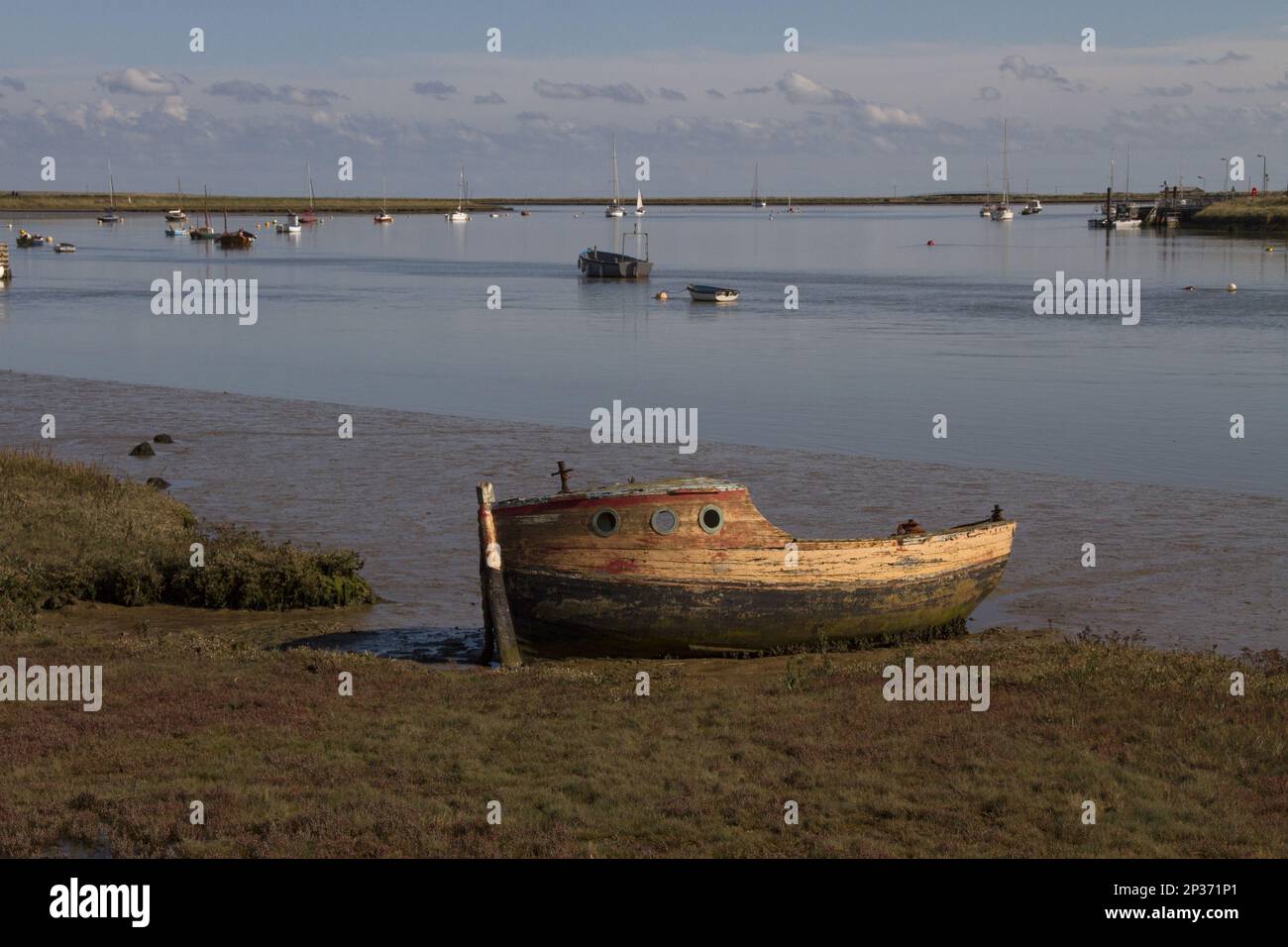 Barca abbandonata sulle pianelle maree del fiume ore vicino a Orford, Suffolk Foto Stock