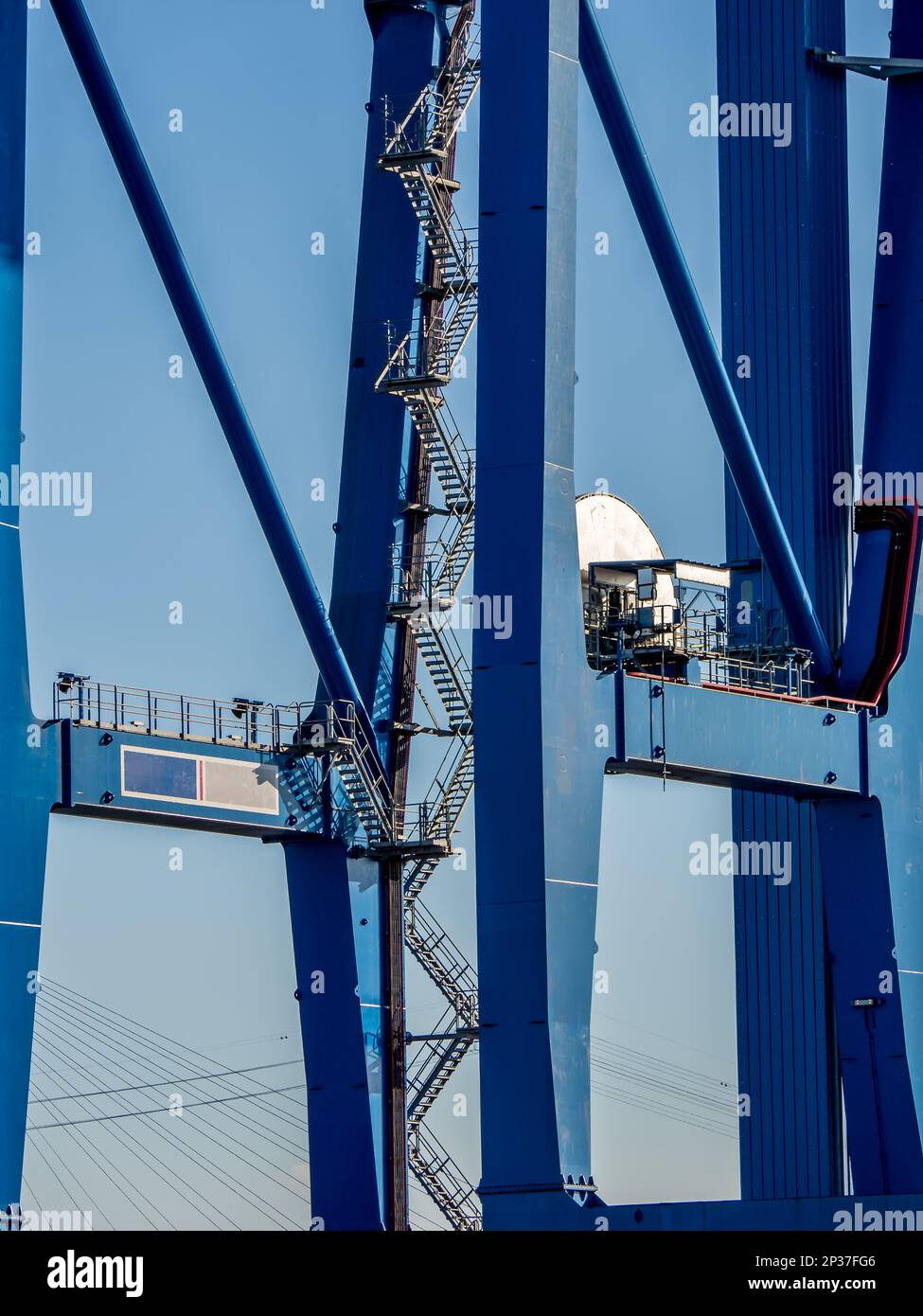 Vista laterale di una parte di una gru blu, compresa una lunga e suggestiva scala, contro il cielo blu, che mostra importanza ed efficienza. Foto Stock