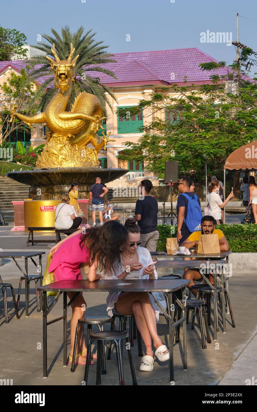 Turisti seduti intorno al Monumento del Drago d'Oro nella città di Phuket, Thailandia, in occasione del famoso mercato di strada a piedi della Domenica Foto Stock