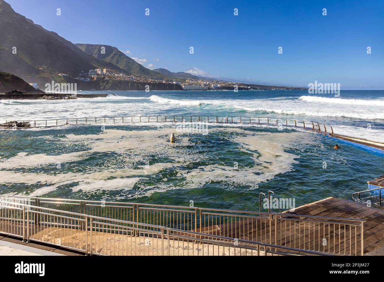 Piscina di acqua di mare a Punta del Hidalgo a Tenerife con la città costiera di Bajamar e il Monte Teide sullo sfondo. Foto Stock