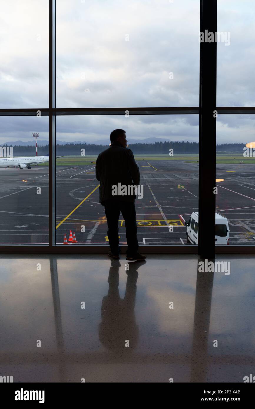 2023 01 02, Ljubljana, Slovenia: La silhouette di un uomo che guarda sul tarmac dell'aeroporto di Ljubljana Foto Stock