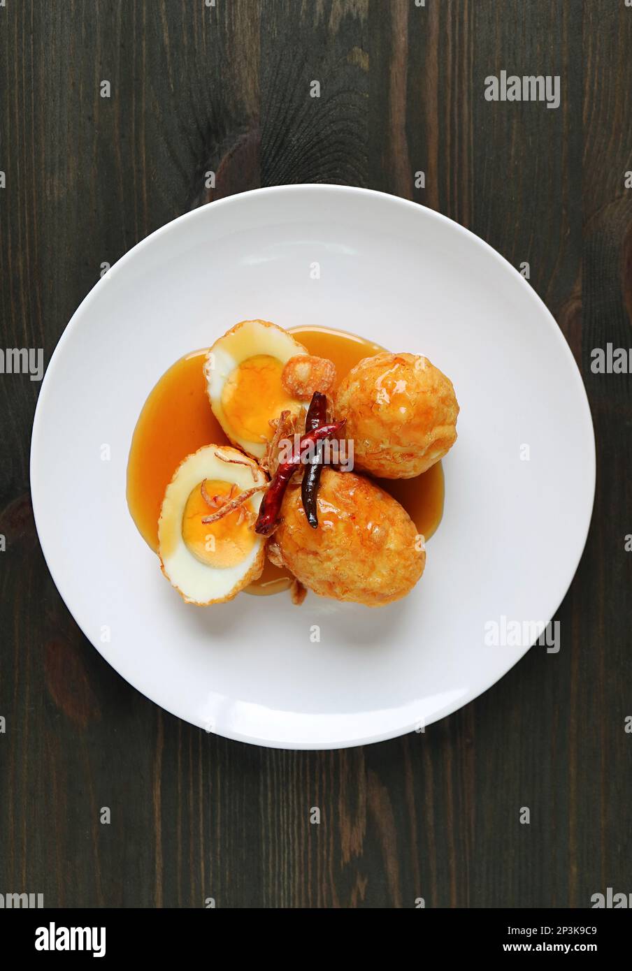 Un piatto di famoso piatto fatto in casa thailandese, Kai Look Keuy o Son in Law uova su sfondo di legno Foto Stock