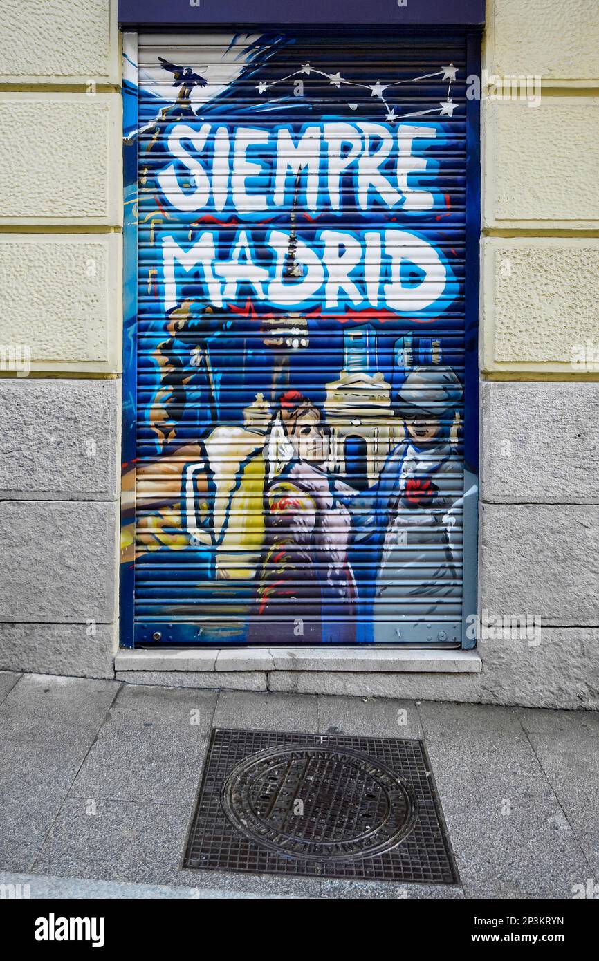 Madrid, Spagna - 23 febbraio 2023: graffiti alla porta di un negozio di madrid con il più rispettabile dipinto con un tipico tombino della città Foto Stock