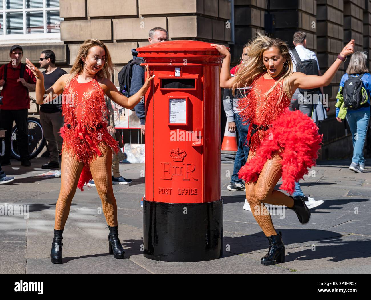 Fringe performer ballare ragazze con fake Postbox, Royal Mile, Edimburgo, Scozia, Regno Unito Foto Stock