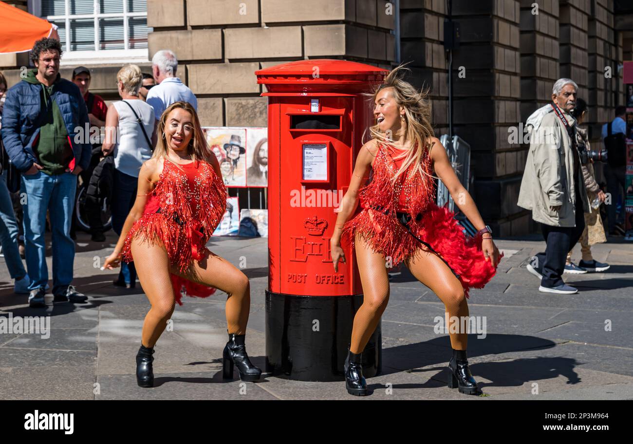 Fringe performer ballare ragazze con fake Postbox, Royal Mile, Edimburgo, Scozia, Regno Unito Foto Stock