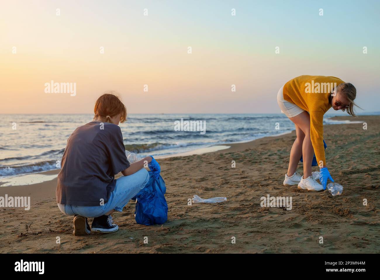 Madre con figlia salvando il pianeta dalla spazzatura. Foto Stock