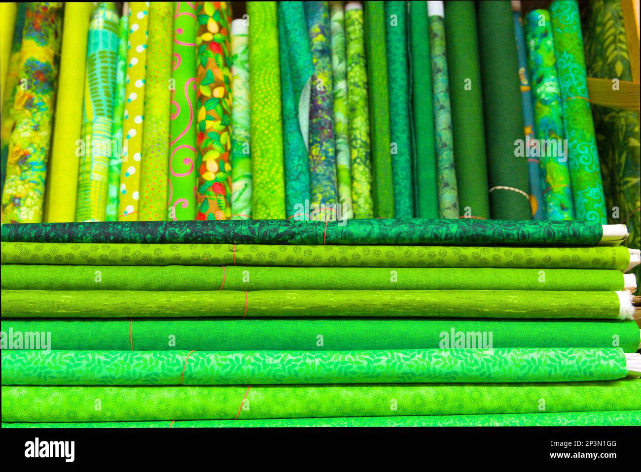 tessuti colorati verdi e gialli in vendita in un negozio Foto Stock