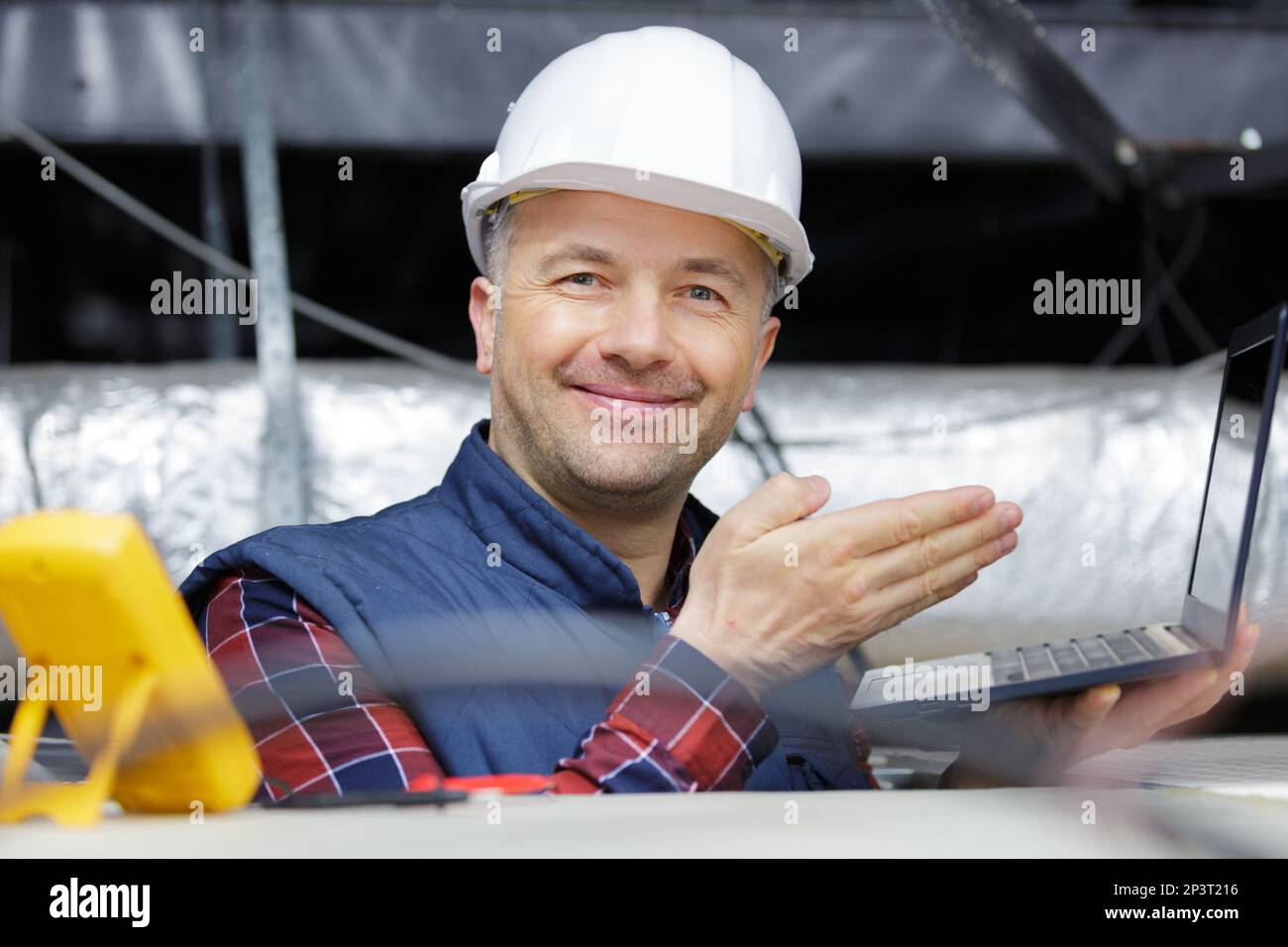 elettricista felice che lavora sulla tensione di soffitto Foto Stock