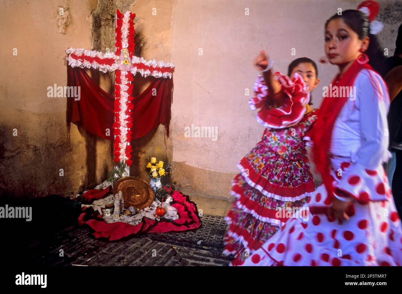 Dia de la Cruz, croce floreale e ragazze in abito tradizionale `un Chavico pa la Cruz´, ad Arco de las Pesas, quartiere Albaicin, Granada, Andalusia, Spagna Foto Stock