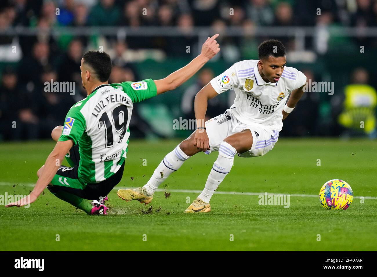 Real Madrid's Rodrygo, right, dribbles the ball against Betis' Luiz Felipe during the Spanish La Liga soccer match between Real Betis and Real Madrid at the Benito Villamarin stadium in Seville, Spain, Sunday, March 5, 2023. (AP Photo/Jose Breton) Foto Stock