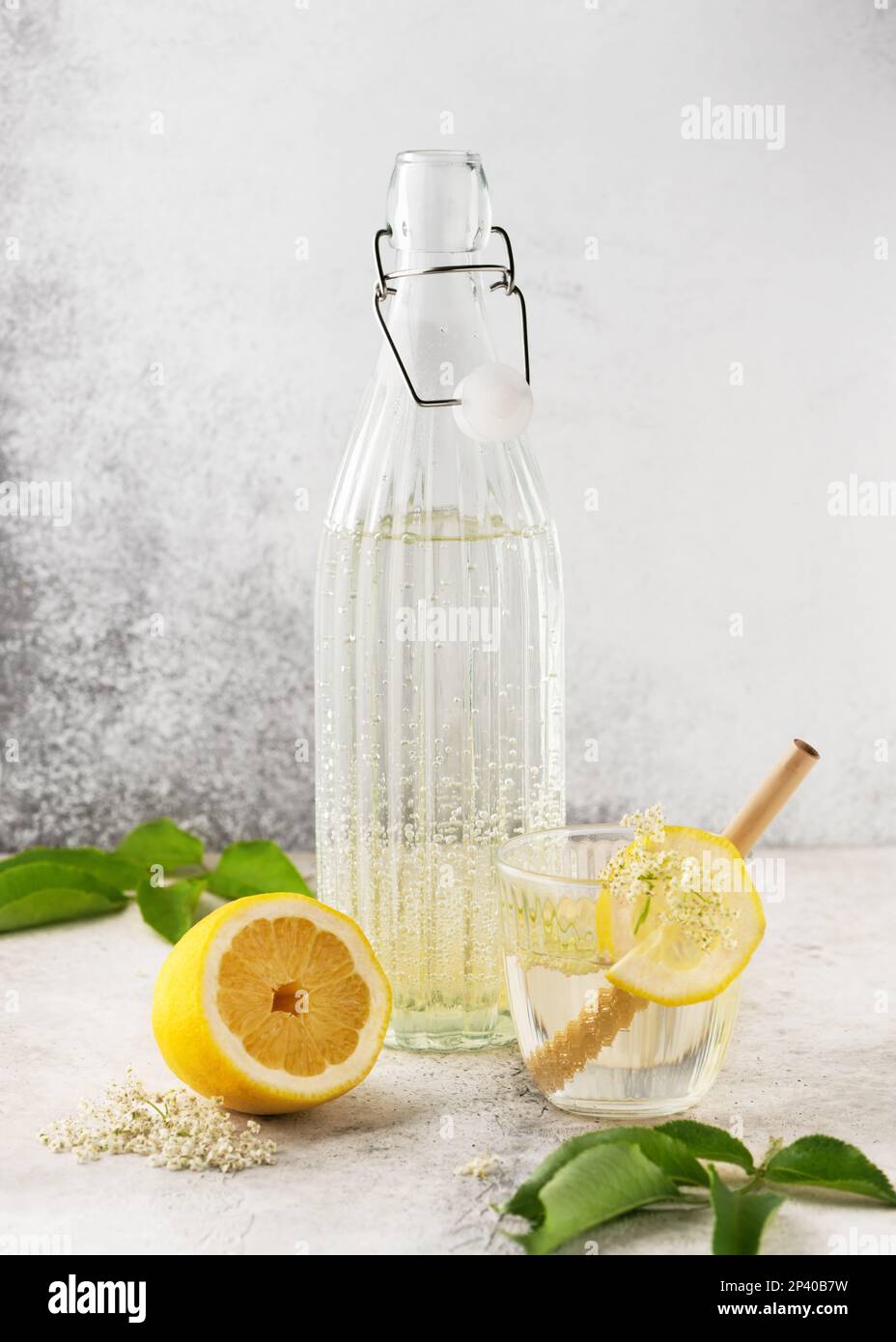 Limonata di fiori di elderfiore fatta in casa in bottiglia di vetro. Drink estivo con fiore di sambuco e limone. Concetto di bevande biologiche. Messa a fuoco selettiva. Spazio di copia. Foto Stock