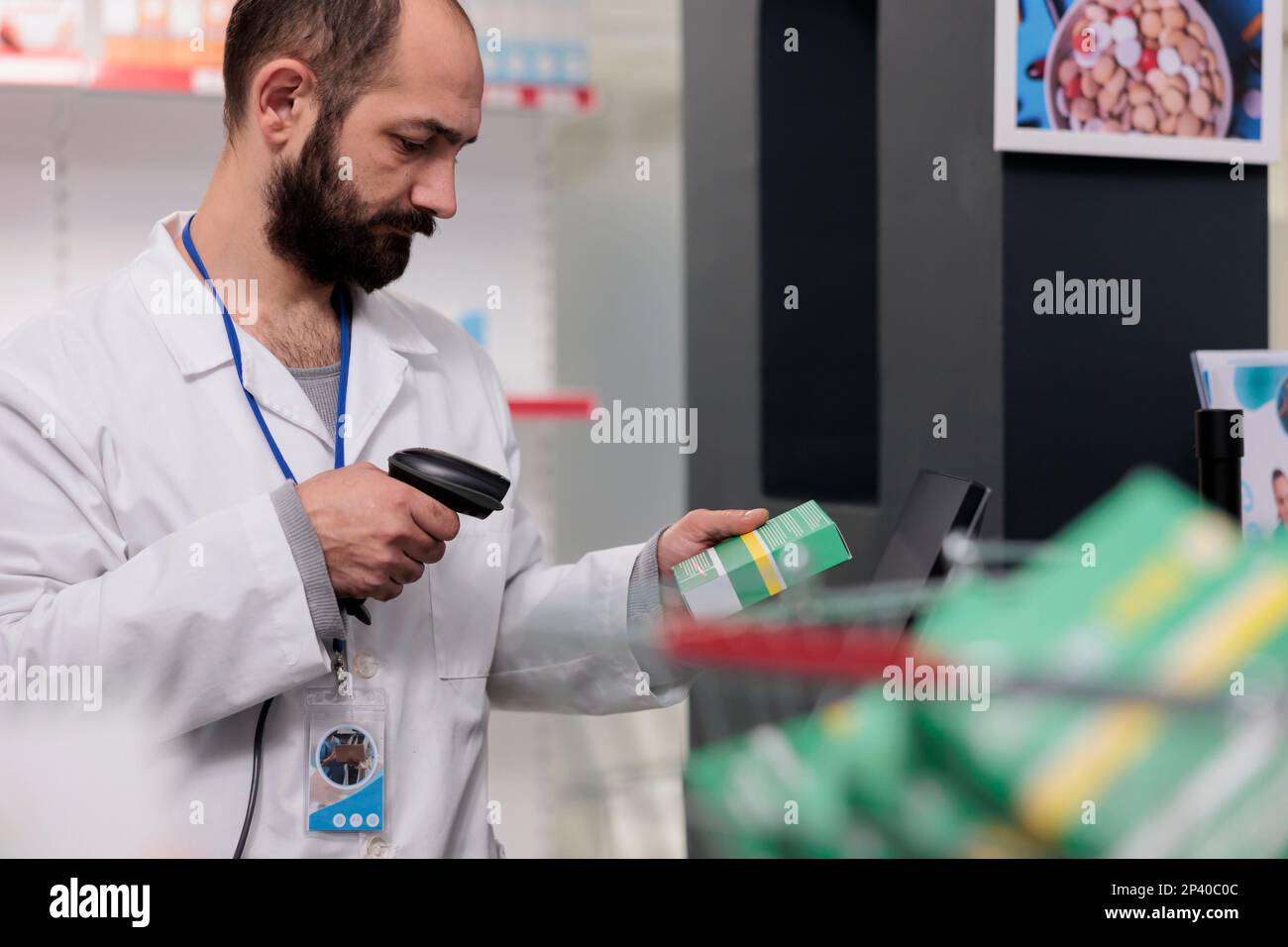 Il farmacista che tiene lo scanner del punto vendita che legge i codici a barre su tutti i pillole e le confezioni per garantire la precisione nell'erogazione dei farmaci. Dipendente farmacia che lavora in farmacia, controllando supplementi Foto Stock