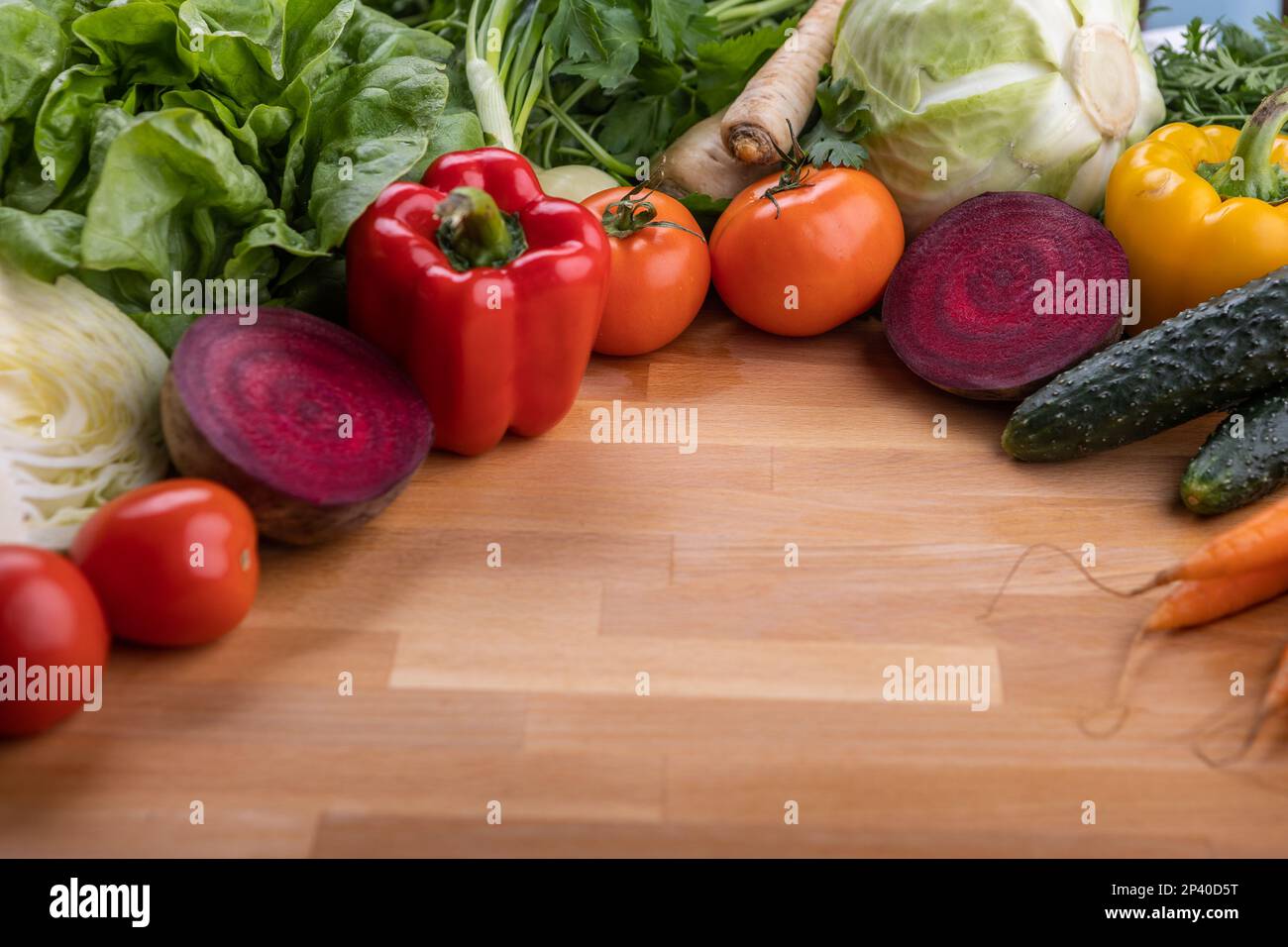 Verdure fresche crude, una fonte di vitamine, ingredienti di una dieta vegetariana. Verdure su fondo di legno Foto Stock