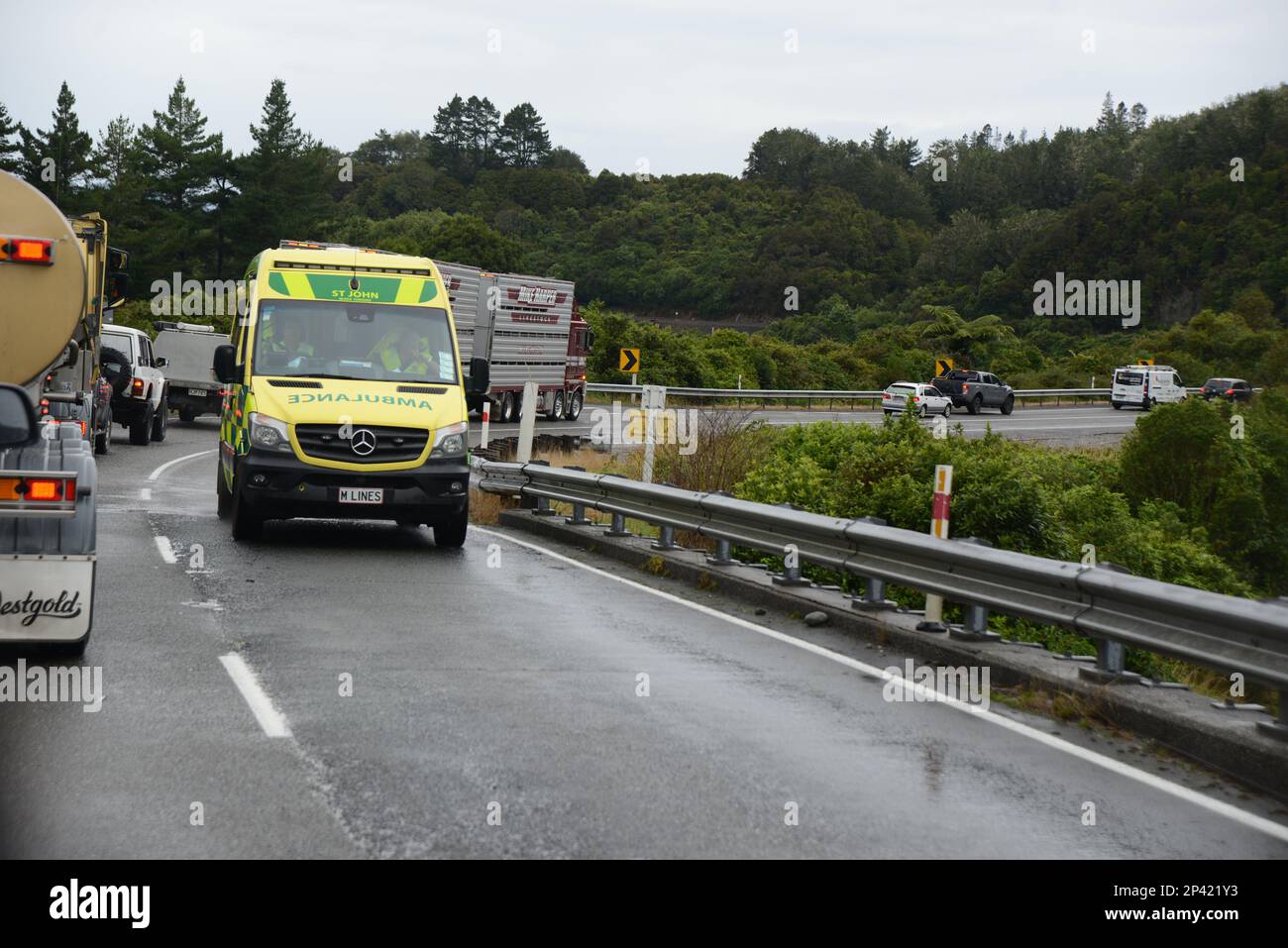 GREYMOUTH, NUOVA ZELANDA, 22 FEBBRAIO 2023: Un'ambulanza passa una linea di traffico dopo aver assistito a un incidente stradale vicino a Dobson, Nuova Zelanda Foto Stock
