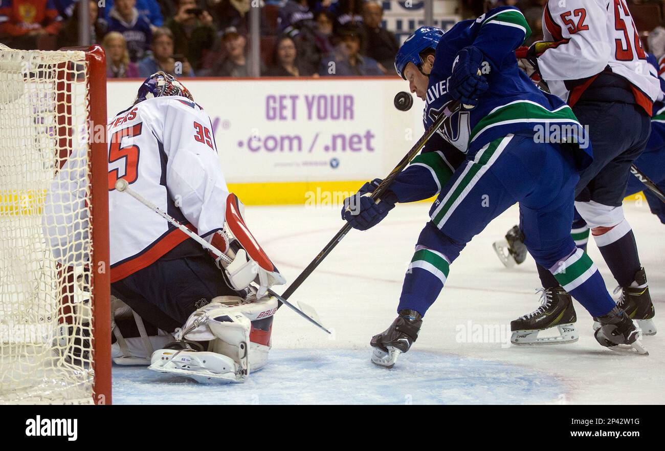 Vancouver Canucks' Derek Dorsett, right, is stopped by Washington Capitals goalie Justin Peters during the first period of an NHL hockey game in Vancouver, British Columbia, on Sunday, Oct. 26, 2014. (AP Photo/The Canadian Press, Darryl Dyck) Foto Stock