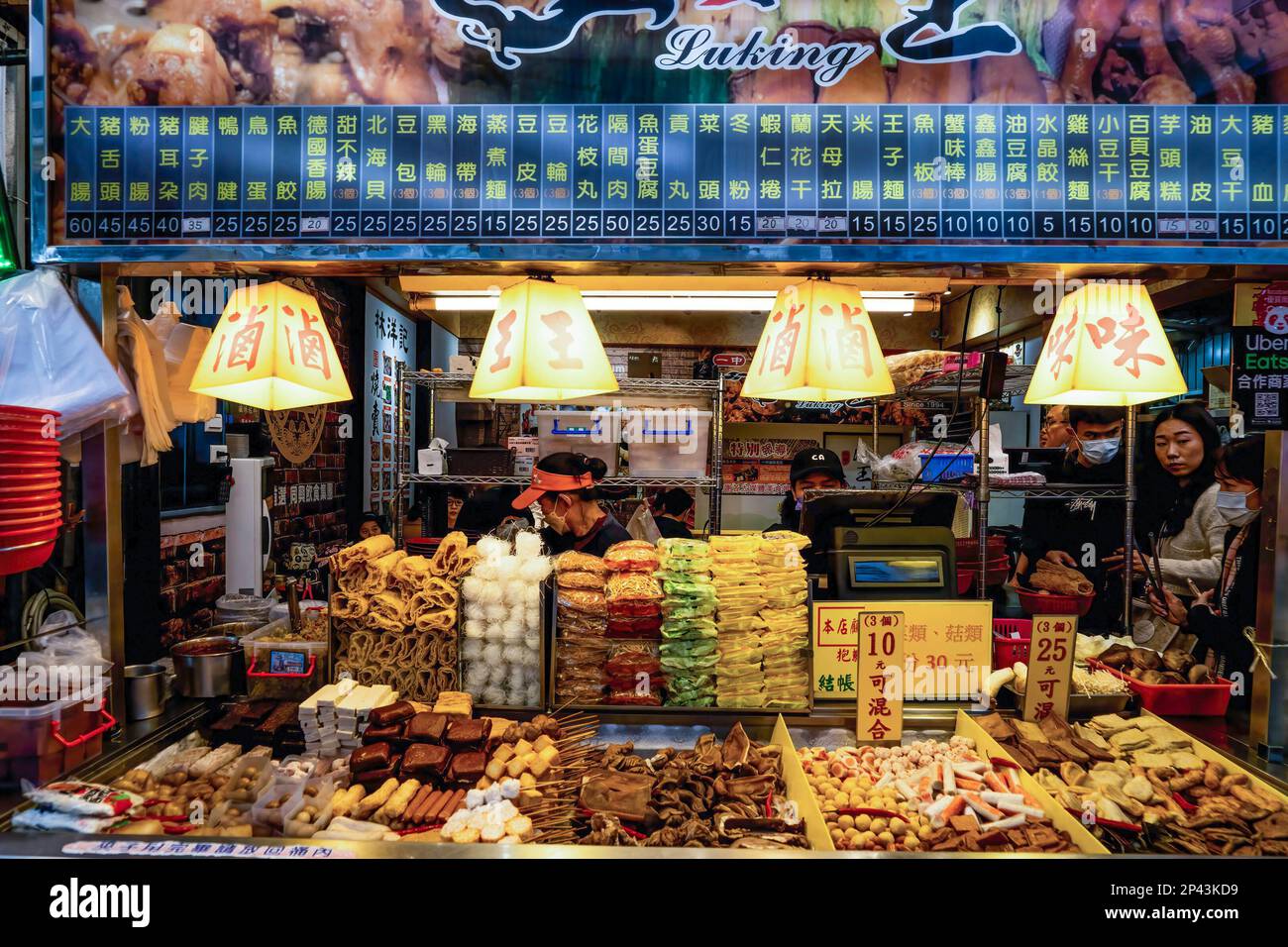 I venditori di cibo di strada aiutano i clienti al loro stand di cibo in un mercato di strada a Taichung. Vita quotidiana a Taichung, la seconda città più grande di Taiwan. Nel tentativo di attirare più turisti internazionali, il governo taiwanese ha recentemente annunciato che avrebbe dato 5000 dollari di Taiwan (circa 165 dollari) come parte di un pacchetto di stimoli per aiutare a sovvenzionare i viaggi per i turisti. Foto Stock