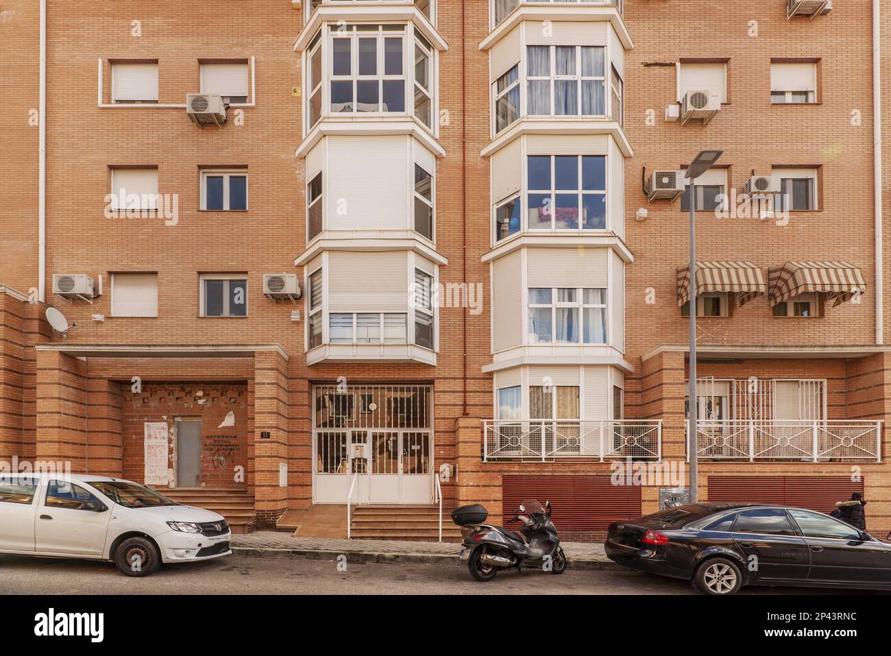 facciata di un edificio residenziale urbano con balconi con rivestimenti in alluminio e vetro bianco e mattoni in argilla Foto Stock